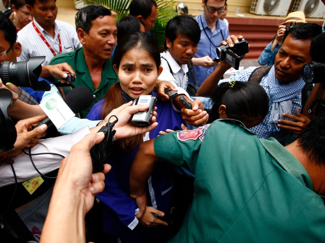 Yorm Bopha, center, is surrounded by a pack of journalists as she is escorted by prison guards at the end of her hearing at the Supreme Court, in Phnom Penh, 22 November 2013, AP Photo/Heng Sinith