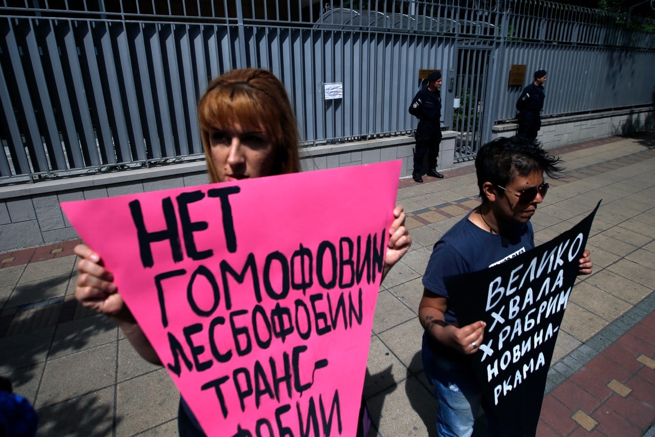 Two Serbian activists hold banners reading, left: "No to homophobia, lesbophobia, transphobia" and right "Thank you brave journalists", during a protest against the reported persecution of gay men in Chechnya outside the Russian embassy in Belgrade, Serbia, 26 April 2017, AP Photo/Darko Vojinovic