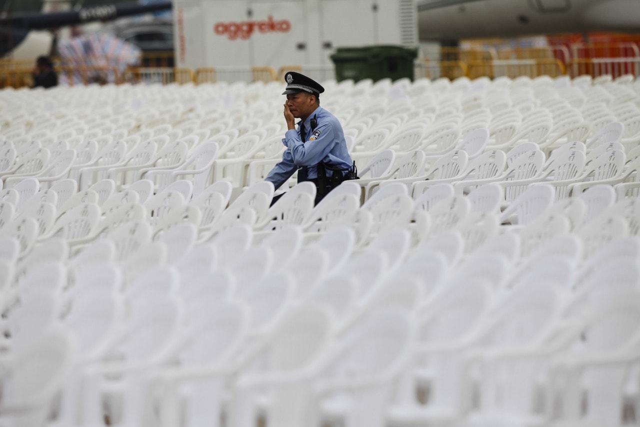 A police officer seats among the chairs set up for the opening ceremony of the Airshow China 2014 in Zhuhai, Guangdong province, 10 November 2014 , Aleksandar Plavevski/Anadolu Agency/Getty Images