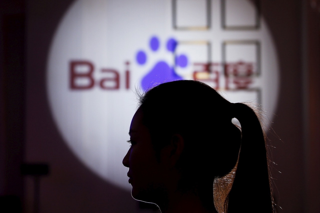 A woman is silhouetted against the Baidu logo at a new product launch from Baidu, in Shanghai, China, 26 November 2015, REUTERS/Aly Song/File Photo