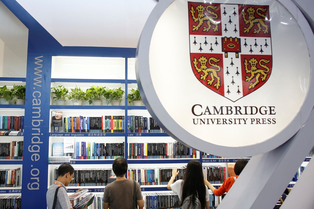 People look at books at the Cambridge University Press (CUP) stall at the Beijing International Book Fair in Beijing, China, 23 August 2017, REUTERS/Thomas Peter