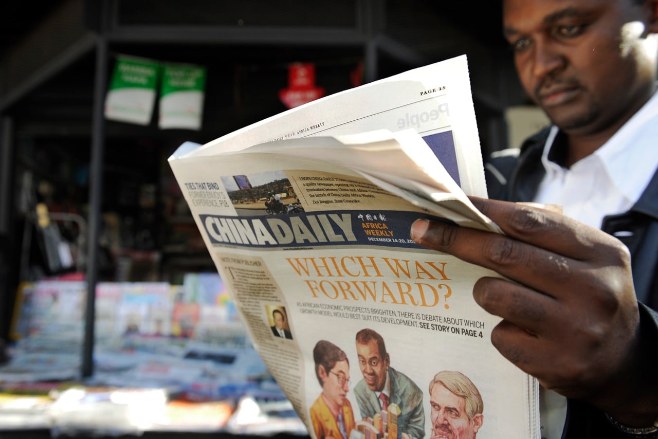 A customer reads a copy of the Africa edition of "China Daily" in front of a news stand in Nairobi, Kenya, 14 December 2012, TONY KARUMBA/AFP/Getty Images