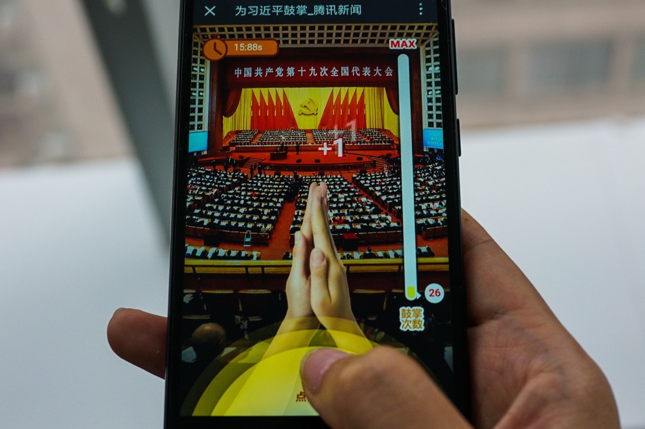 A woman plays a game called 'Clap for Xi Jinping: A Great Speech', in Shanghai, 19 October 2017; the WeChat game allows smartphone users to retroactively applaud Xi's more than three-hour opening speech, CHANDAN KHANNA/AFP/Getty Images