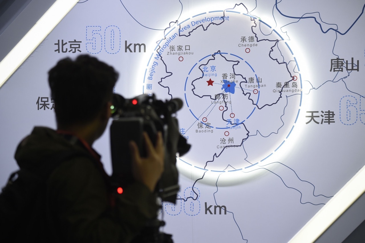 A journalist takes a video in front of a map of Beijing and Heibei province during a tour arranged by the press center for the 19th Communist Party Congress at an exhibition center in China's Hebei province, 22 October 2017, WANG ZHAO/AFP/Getty Images