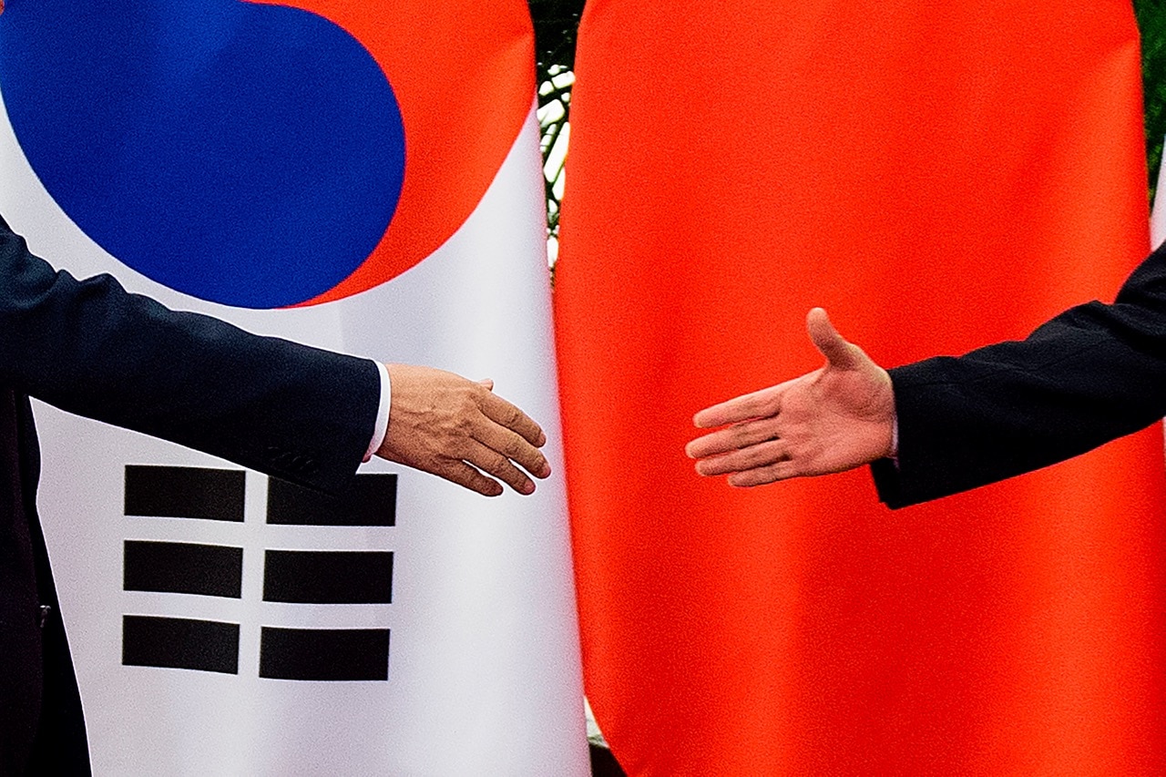 South Korean President Moon Jae-In (L) shakes hands with China's Premier Li Keqiang (R) at the Great Hall of the People in Beijing, 15 December 2017, NICOLAS ASFOURI/AFP/Getty Images