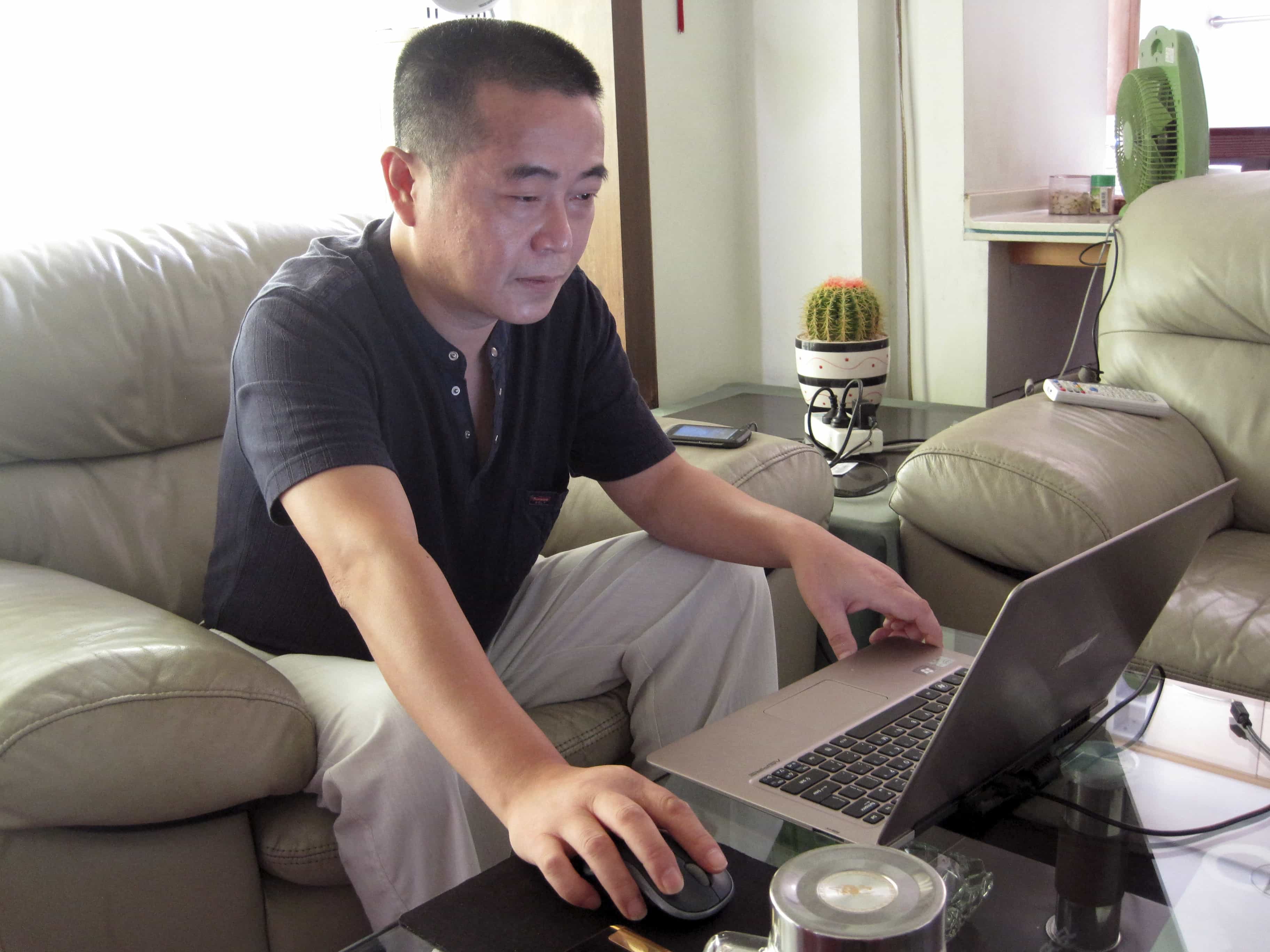 In this 18 September 2012 photo, veteran rights activist Huang Qi works on his laptop in his home in Chengdu in southwestern Sichuan province, AP Photo/Gillian Wong