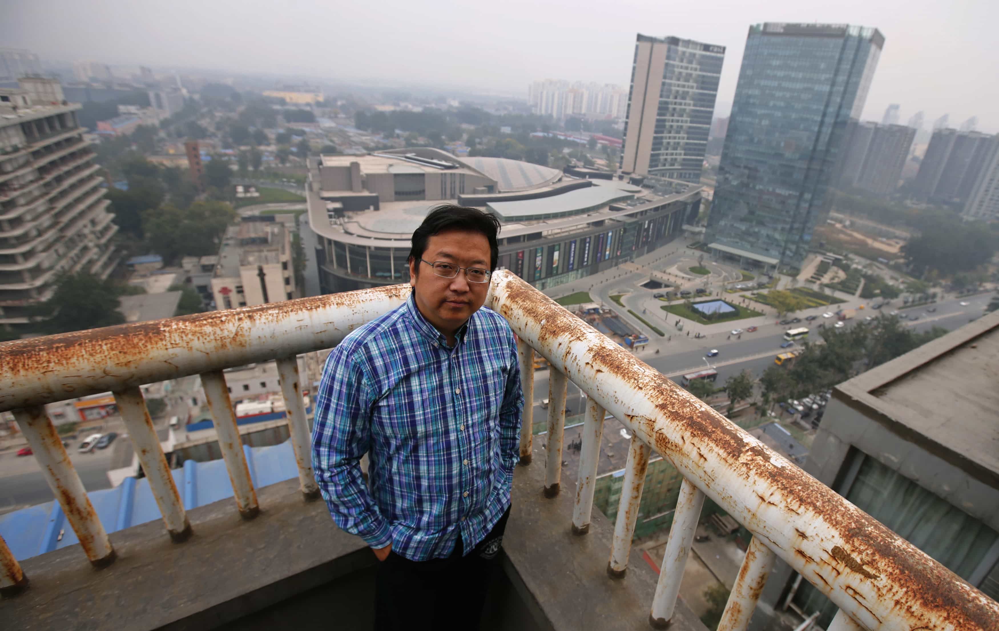 Chinese cartoonist Wang Liming poses on the balcony of his apartment before an interview with Reuters in Beijing, 22 October 2013, REUTERS/Petar Kujundzic