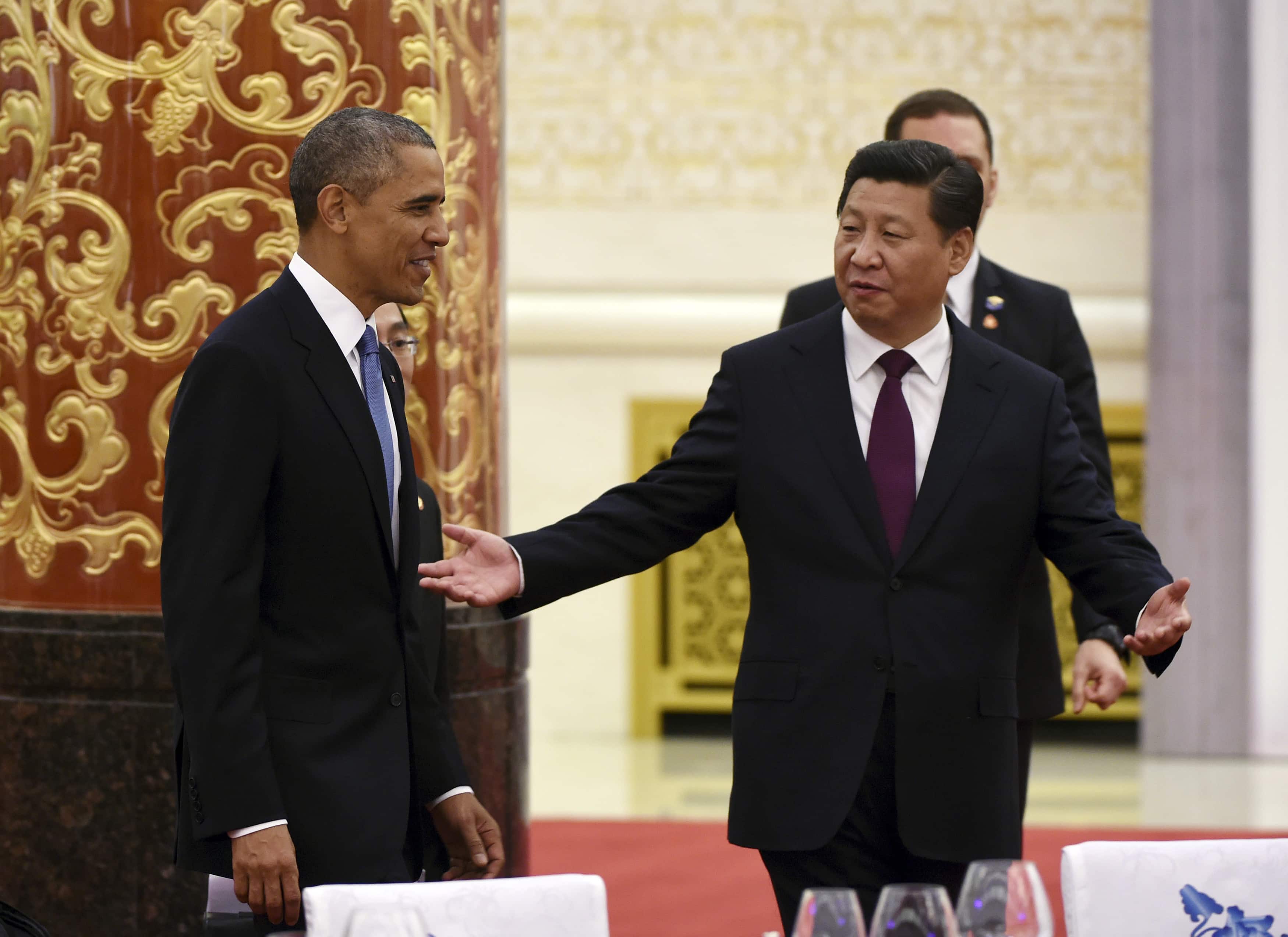 Chinese President Xi Jinping gestures to U.S. President Barack Obama (L) as they arrive for a lunch banquet in the Great Hall of the People in Beijing, 12 November 2014, REUTERS/Greg Baker/Pool