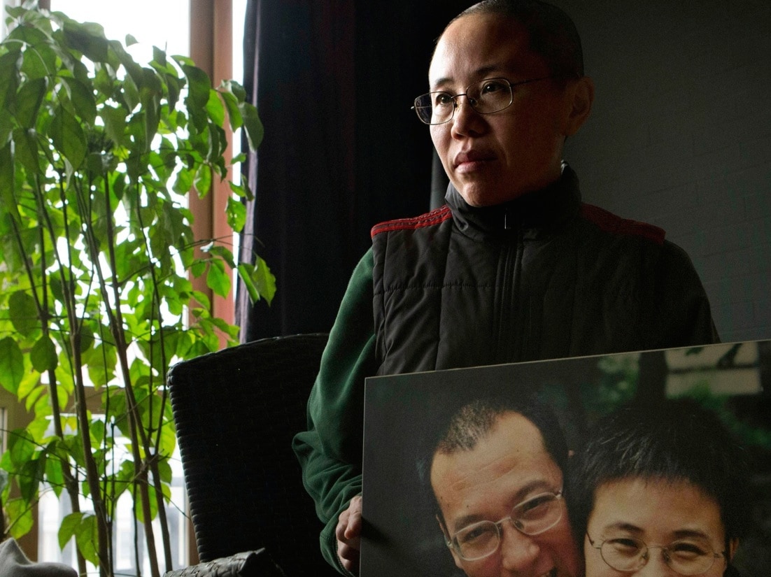 In this 6 December 2012 file photo, Liu Xia, the wife of China's jailed Nobel Peace Prize laureate Liu Xiaobo, poses with a photo of her and her husband during an interview at her home in Beijing, AP Photo/Ng Han Guan, File