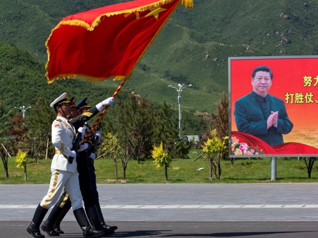 Chinese flag bearers practice marching near a portrait of Chinese President Xi Jinping at a camp on the outskirts of Beijing, 22 August 2015, AP Photo/Ng Han Guan