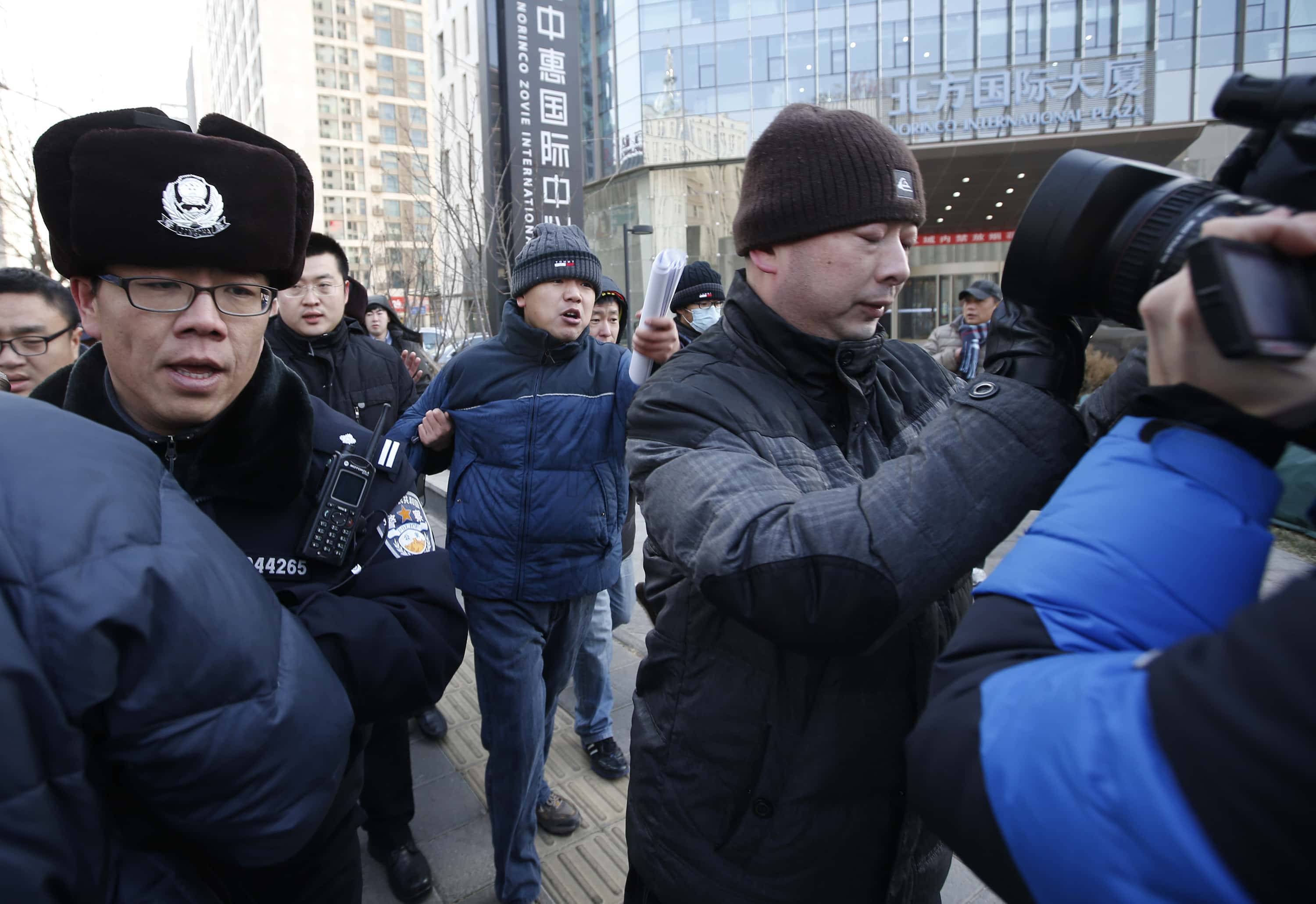 Policemen block a group of journalists trying to interview Zhang Qingfang (C with hat), the lawyer of Xu Zhiyong, after Xu's trial in Beijing, 26 January 2014, REUTERS/Kim Kyung-Hoon