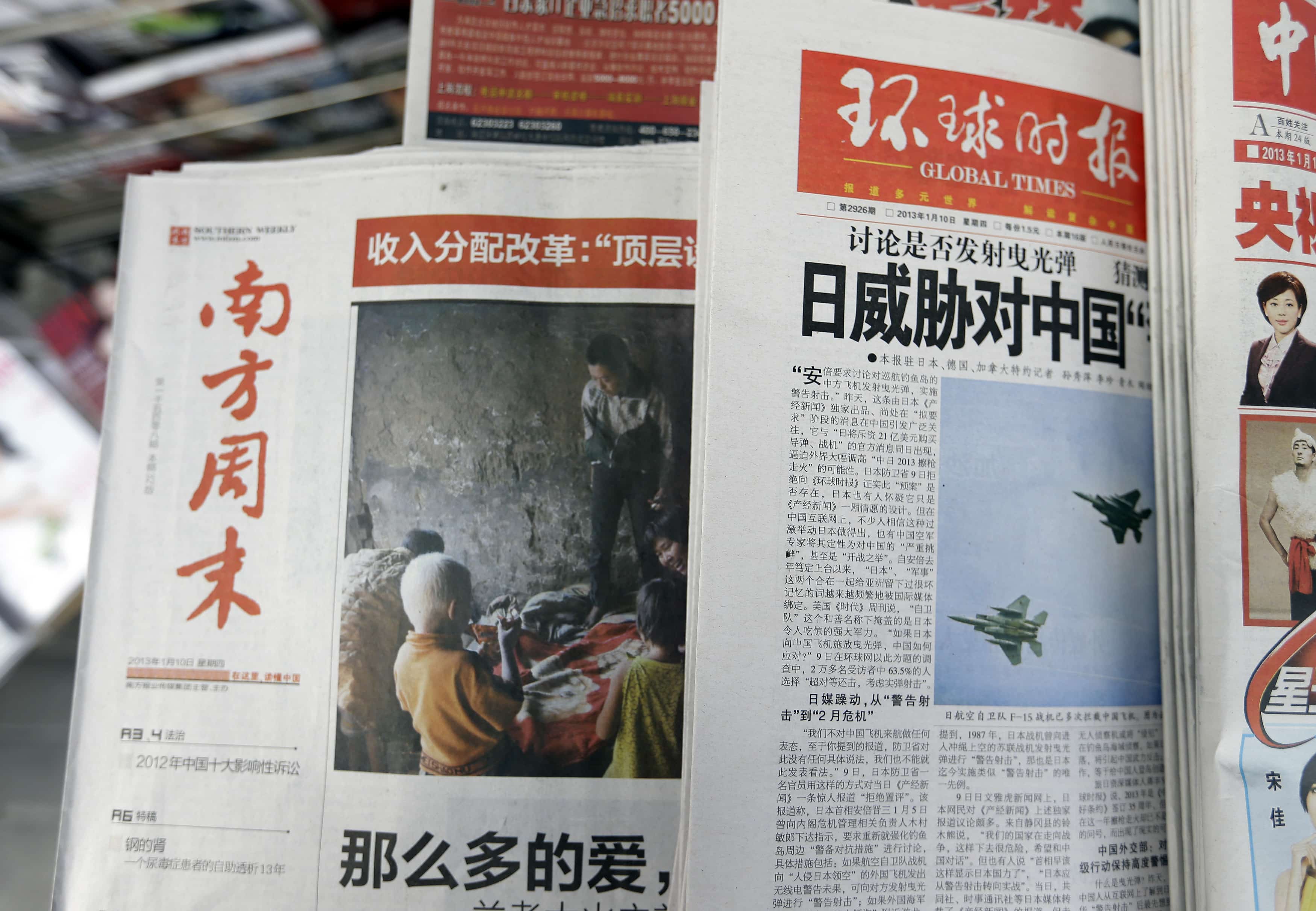 A stack of Southern Weekly (L) are left on display next to a stack of the Global Times at a newsstand in Beijing on 10 January 2013, REUTERS/Jason Lee