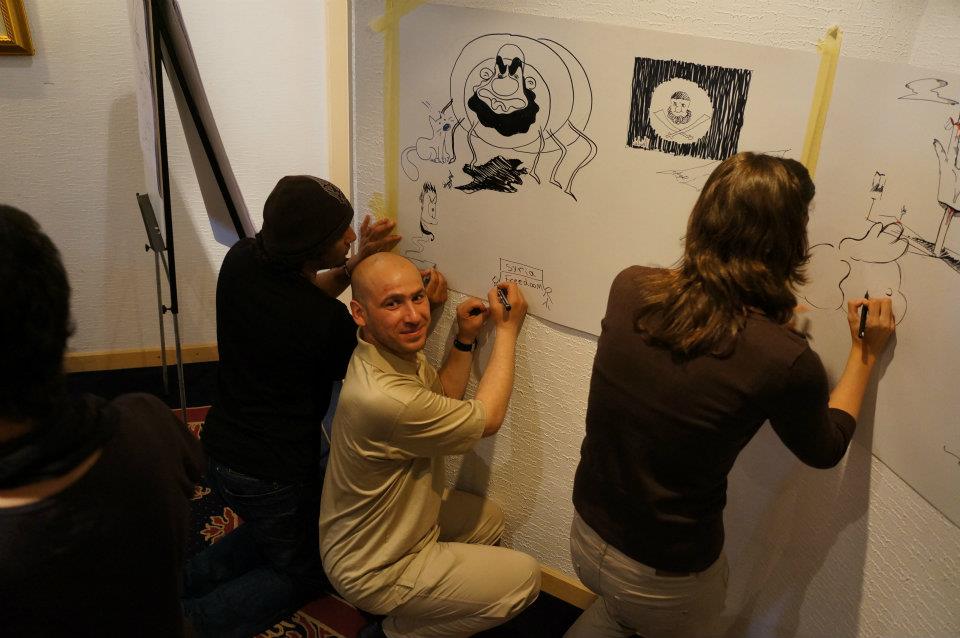 Regional cartoonists draw cartoons collectively as part of the workshop organised by the IFEX-TMG