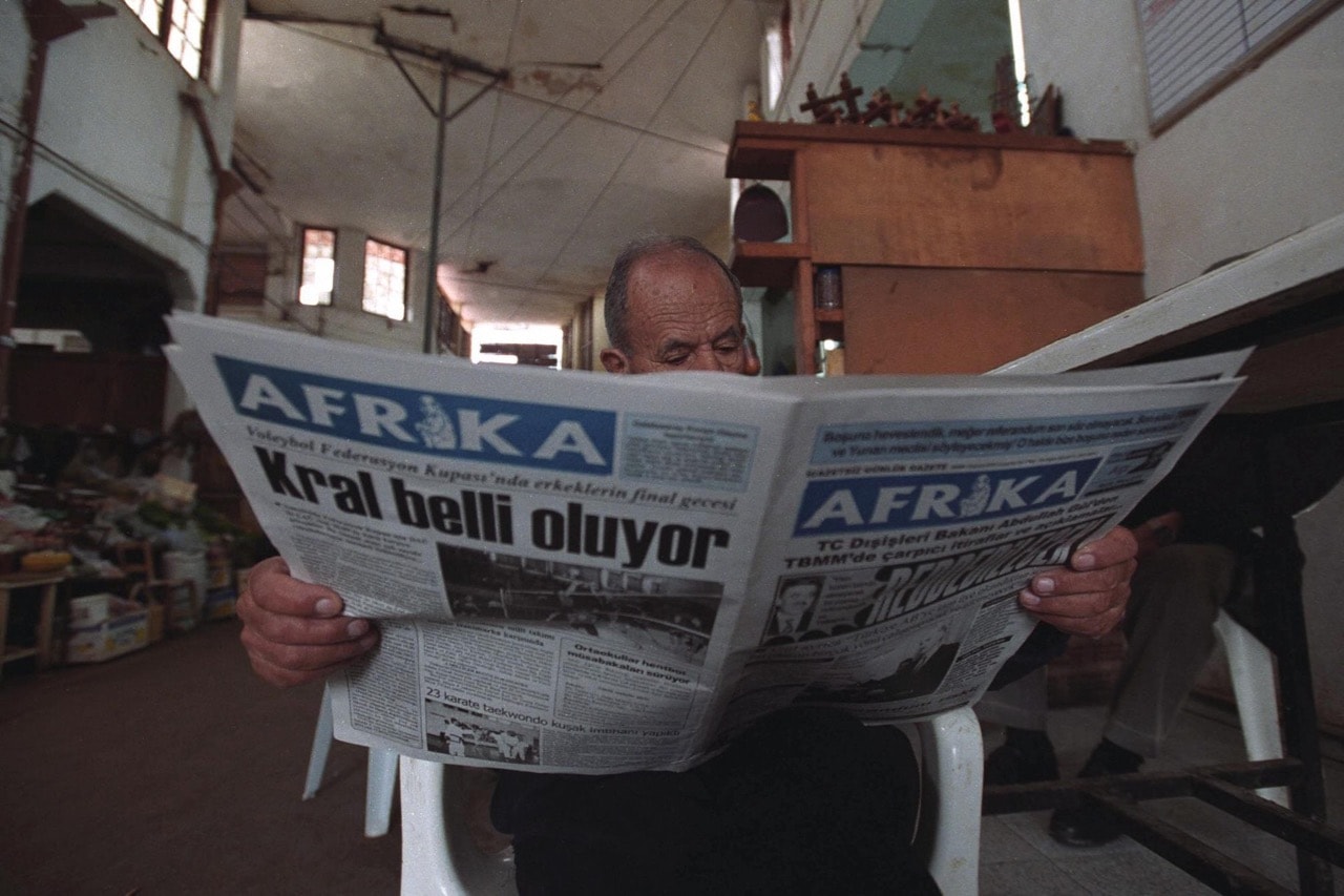 A Turkish Cypriot man reads a copy of the "Afrika" newspaper at a market on the Turkish side of Nicosia, Cyprus, 25 February 2004, LAURA BOUSHNAK/AFP/Getty Images