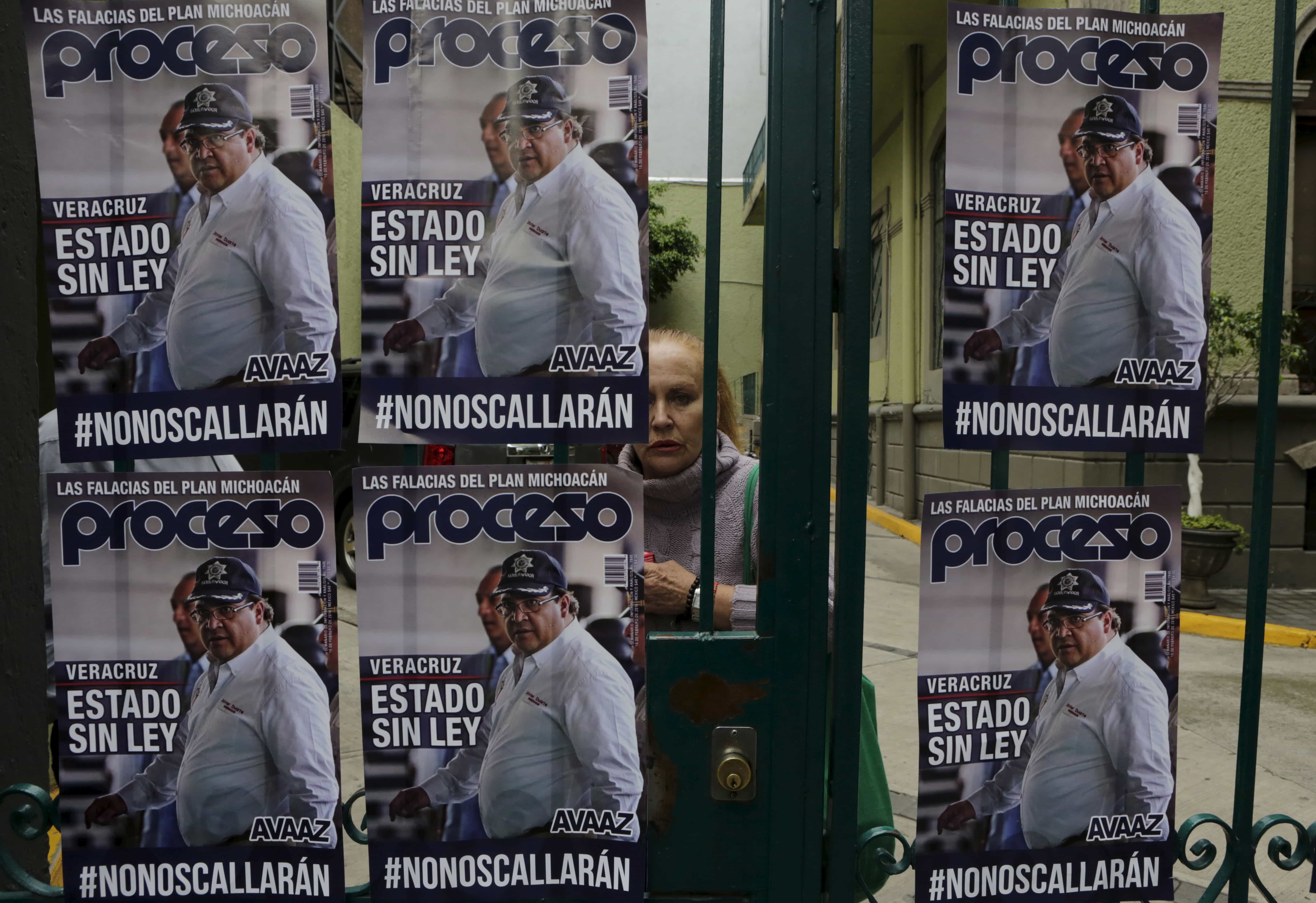 A passerby looks at posters of Veracruz state governor Javier Duarte with the words "State without law" during a demonstration outside the Government of Veracruz building in Mexico City on Aug. 31, 2015 against the murder of photojournalist Ruben Espinosa and four women, REUTERS/Henry Romero