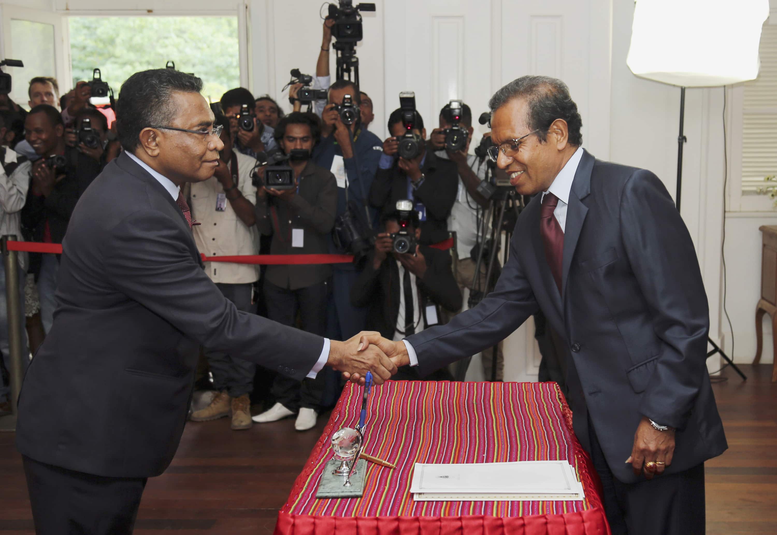 Reporters look on as East Timor's new Prime Minister Rui Araujo (L) shakes hands with President Taur Matan Ruak (R) at an innauguration ceremony at the President's office in Dili, 16 February 2015, REUTERS/Lirio Da Fonseca