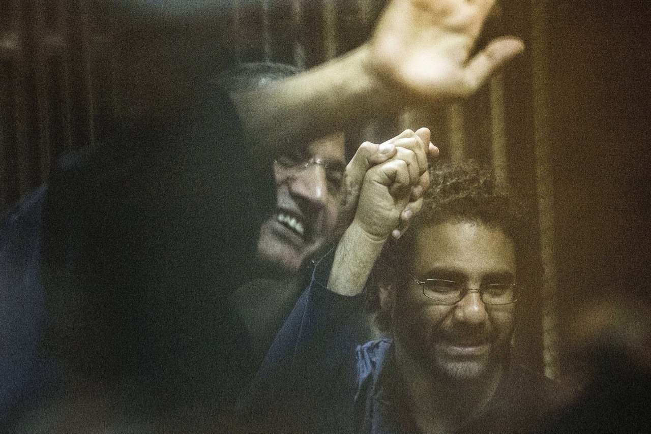 Egyptian activist and blogger Alaa Abdel Fattah (R) and Islamist Essam Sultan hold hands as they attend their trial for insulting the judiciary, in Cairo, 23 May 2015, KHALED DESOUKI/AFP/Getty Images