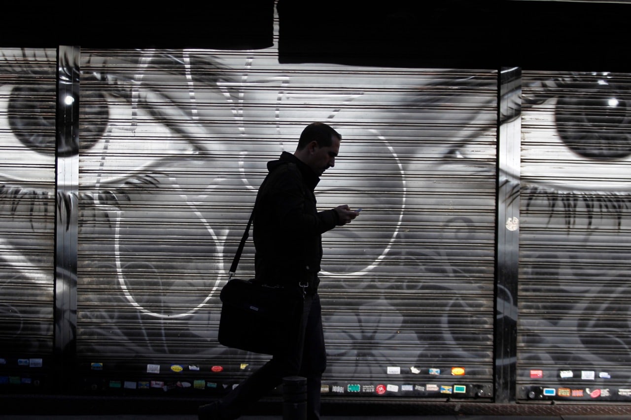 A man looks at his cellphone as he walks on the street in Madrid, Spain, 31 October 2013, AP Photo/Francisco Seco, File