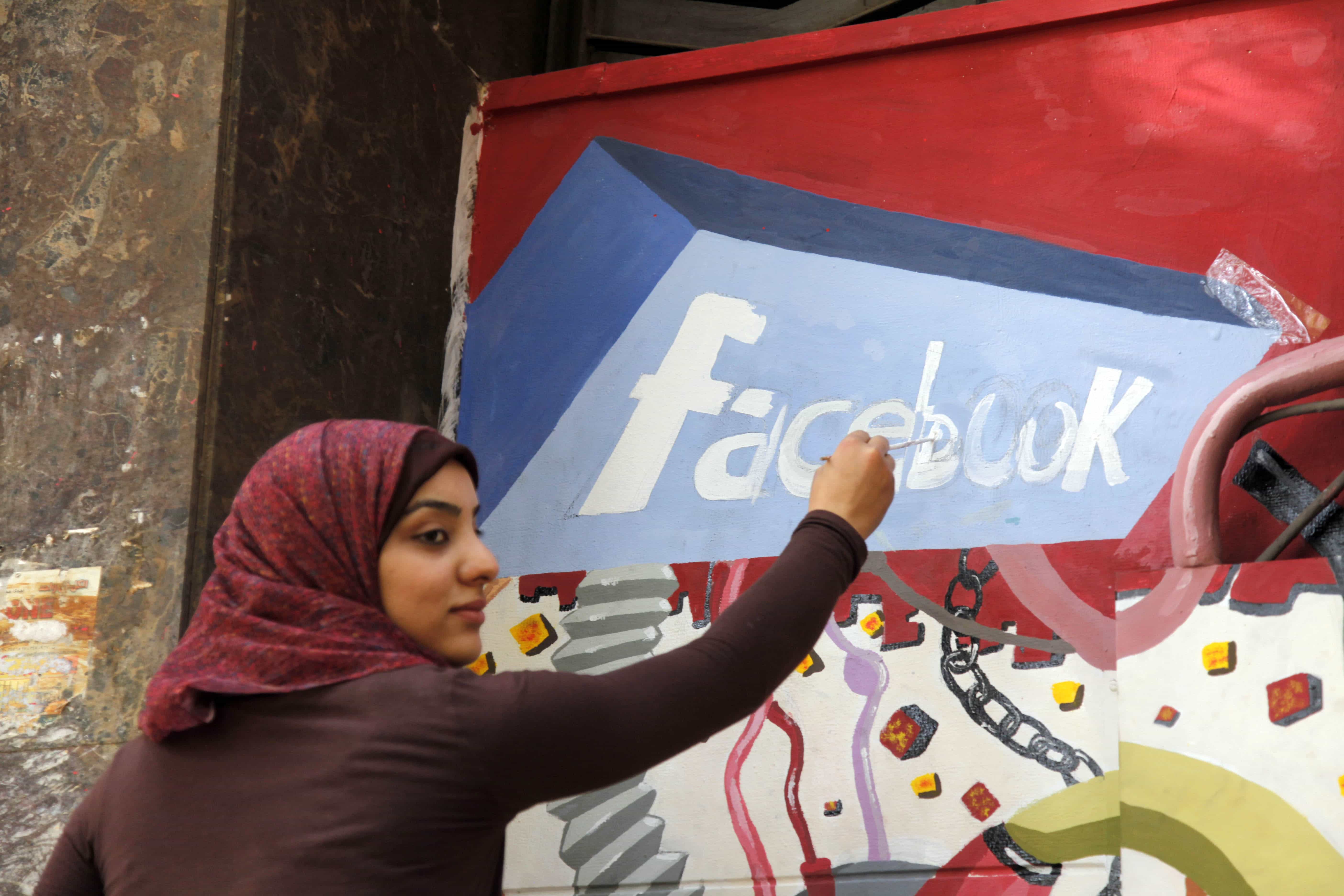 In this March 30, 2011, file photo, an art student paints the Facebook logo on a mural commemorating the revolution that overthrew Hosni Mubarak in Cairo, Egypt, AP Photo/Manoocher Deghati, File