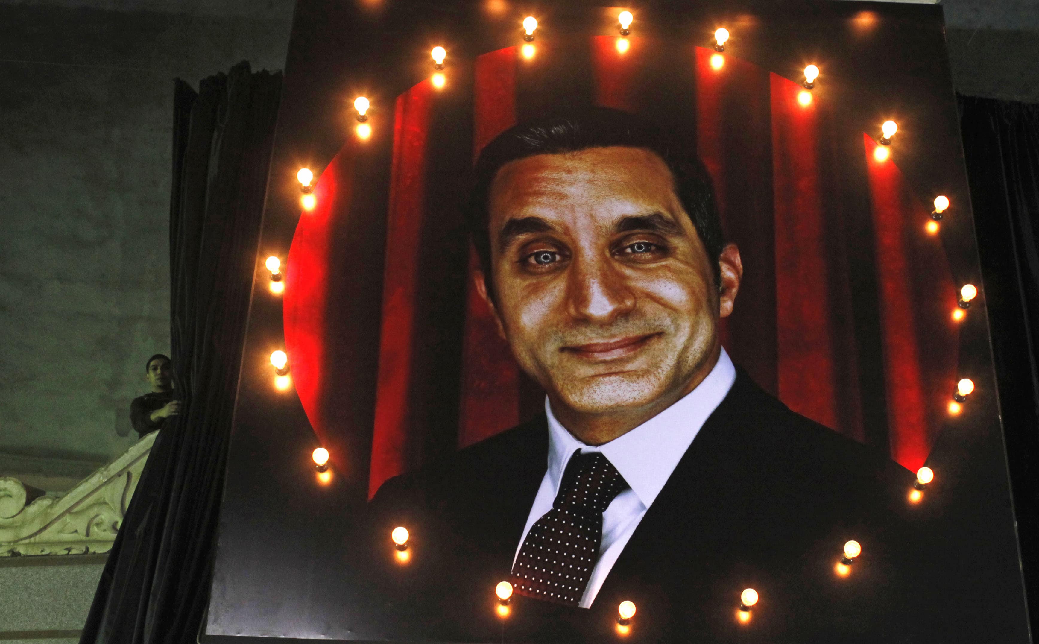 A worker lifts curtains in a theater to reveal a picture of Egyptian satirist Bassem Youssef for his comic show "Al-Bernameg" (The Programme), in Giza 15 January 2013, REUTERS/Asmaa Waguih