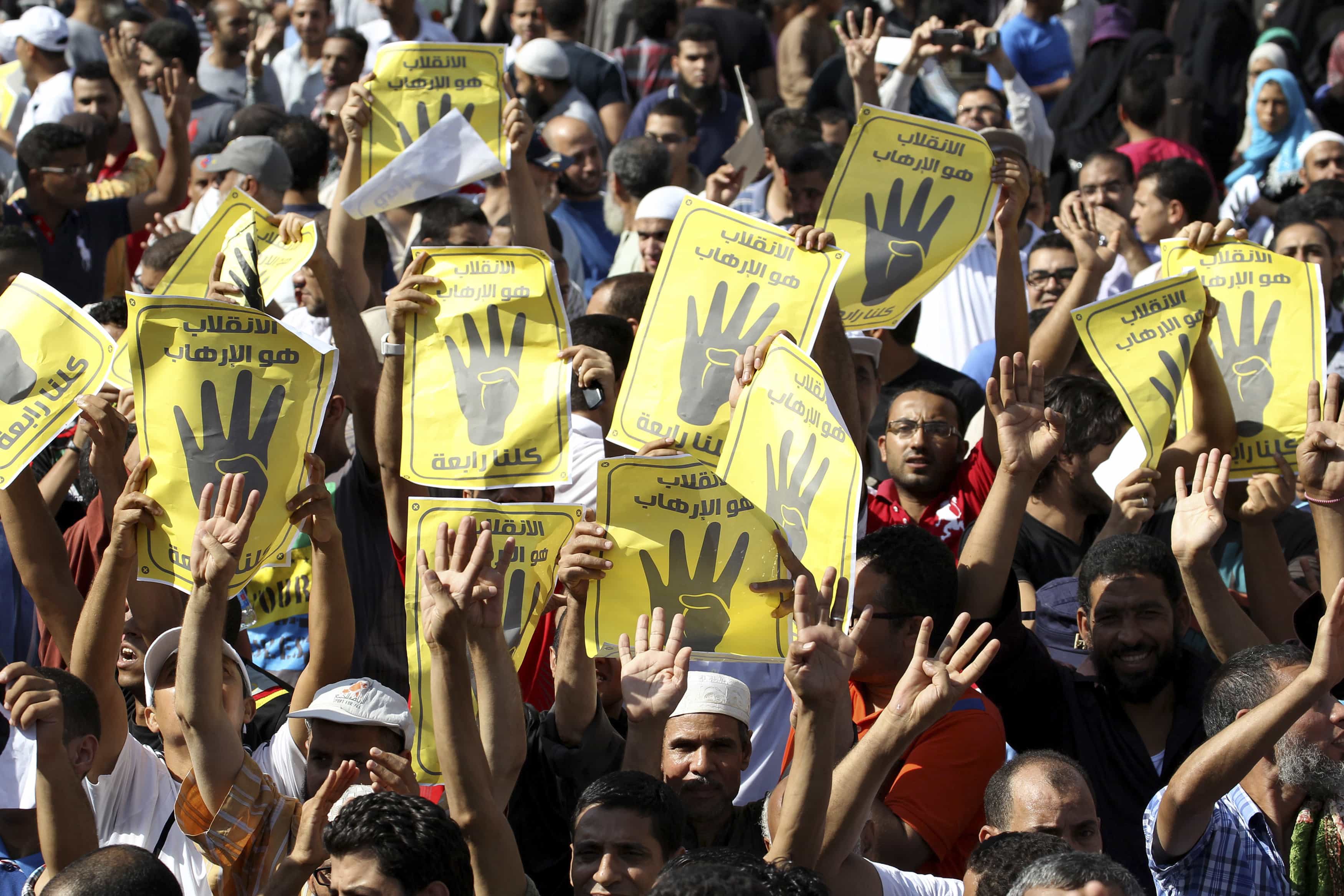 Supporters of Muslim Brotherhood hold up posters of the "Rabaa" gesture, in reference to the police clearing of Rabaa Adawiya protest camp on 24 August, during a protest in Cairo 23 August 2013, REUTERS/Muhammad Hamed