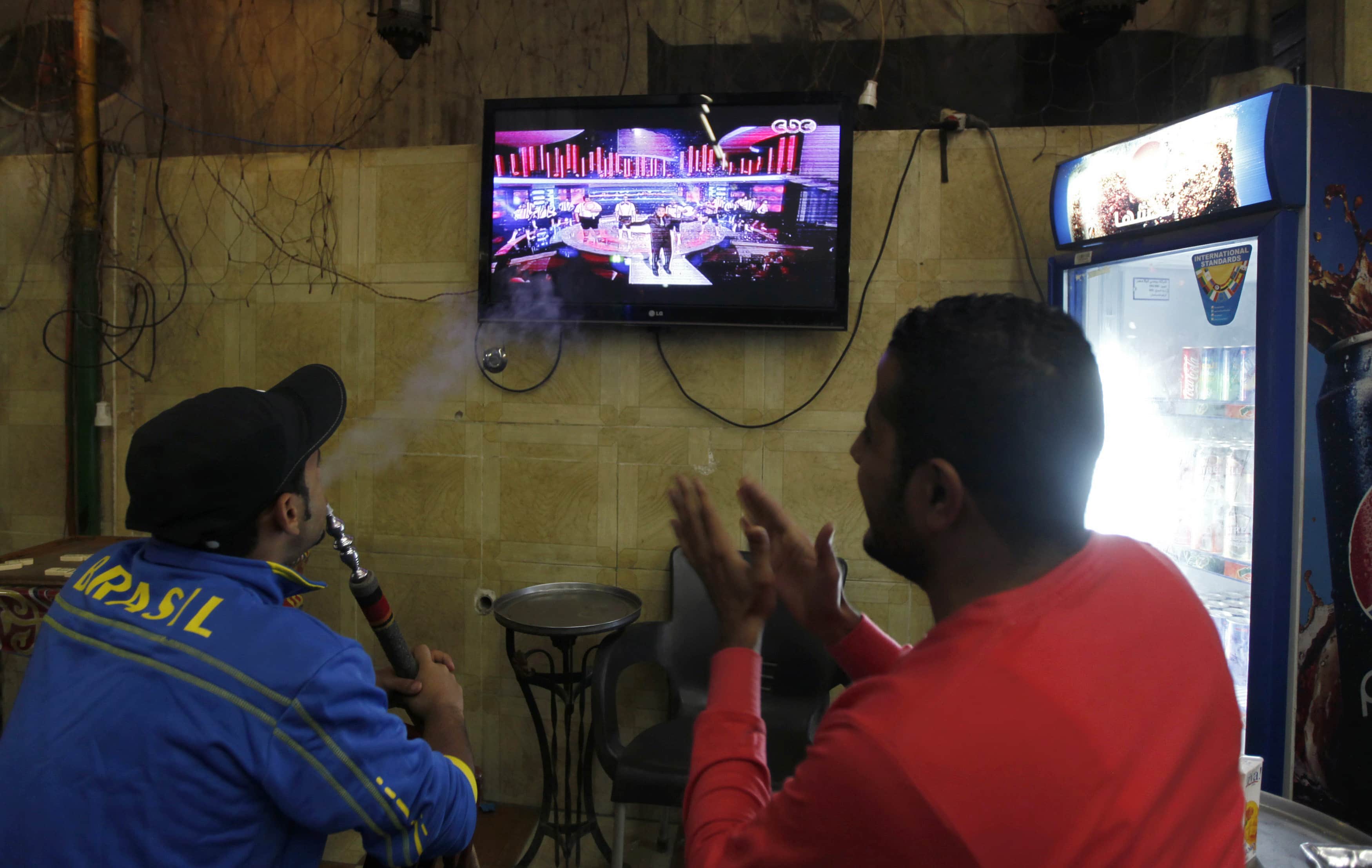 Egyptians watch the first episode of a show by Egypt's most prominent television satirist, Bassem Youssef, called "El Bernameg" in Cairo, 25 October 2013 , REUTERS/Mohamed Abd El Ghany