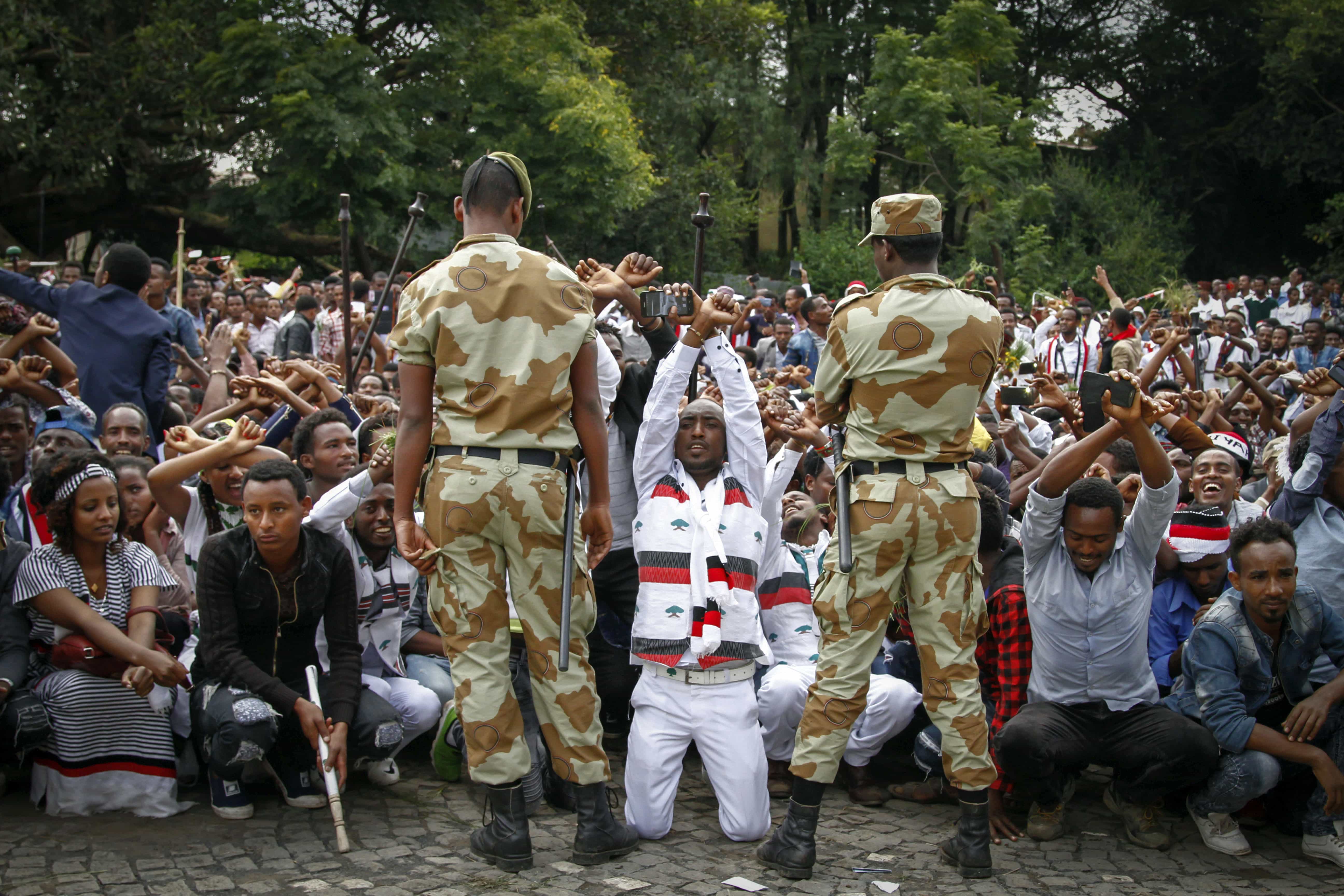 In this photo taken on 2 October 2016, Ethiopian soldiers try to stop protesters in Bishoftu, Ethiopia, AP Photo