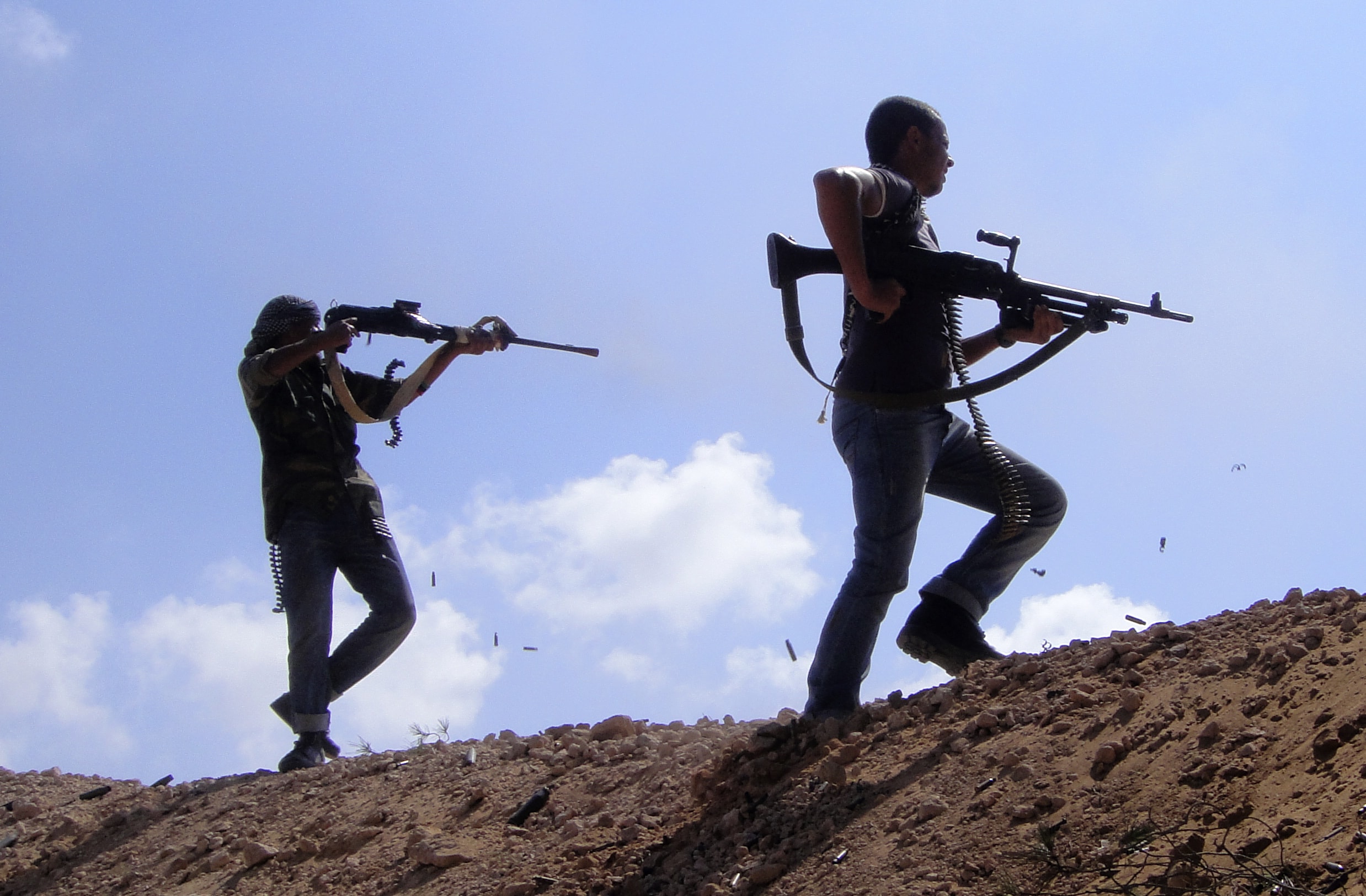 This 21 June 2011 photo by Abdelqadir Fassouk shows Libyan rebels firing their weapons towards pro-Moammar Gadhafi forces in Misrata, Libya, AP/Abdelqadir Fassouk
