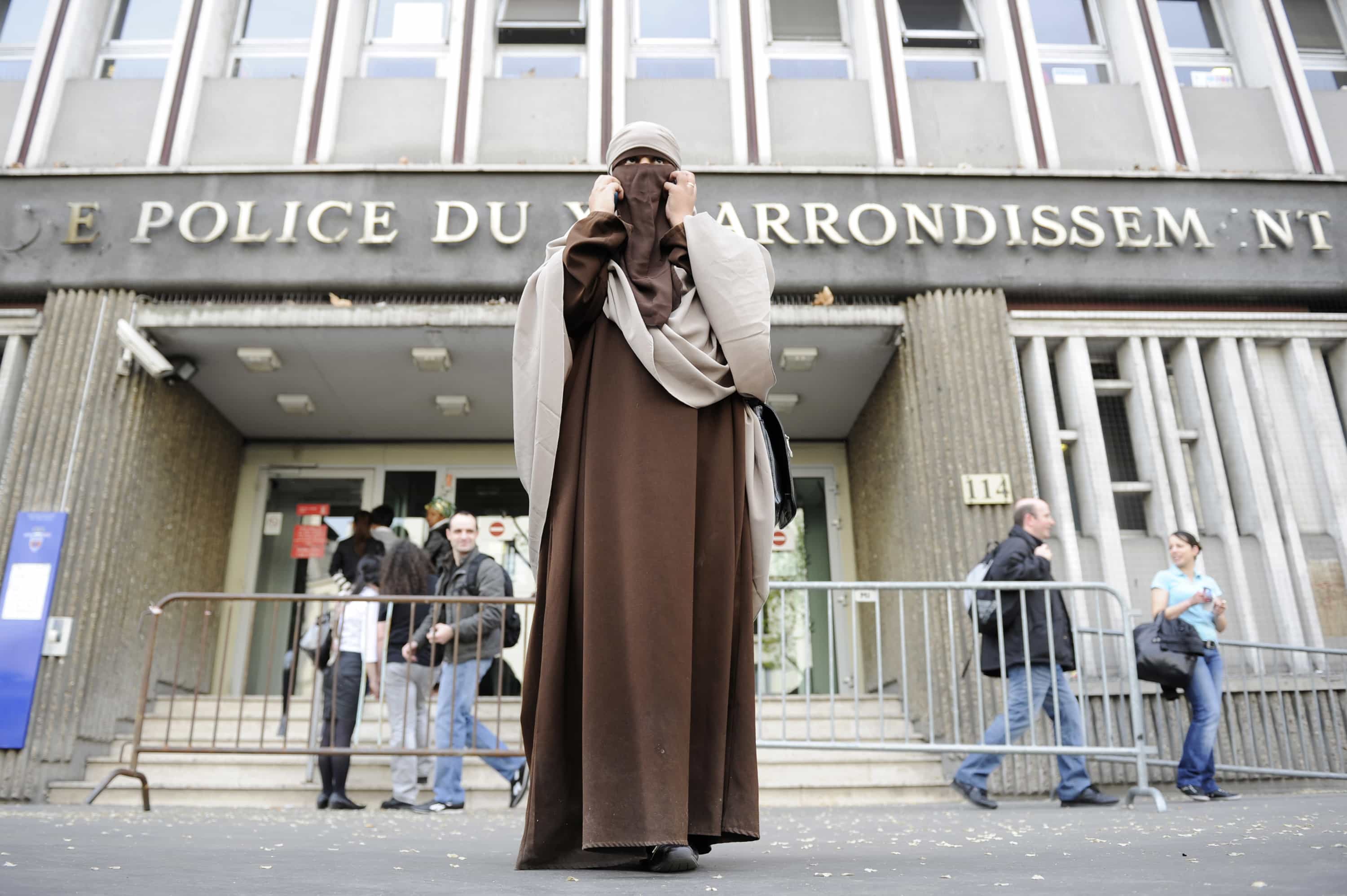 Kenza Drider, a French Muslim of North African descent, wearing a niqab, speaks on the phone after her release from a police station in Paris, 11 April 2011, REUTERS/Gonzalo Fuentes