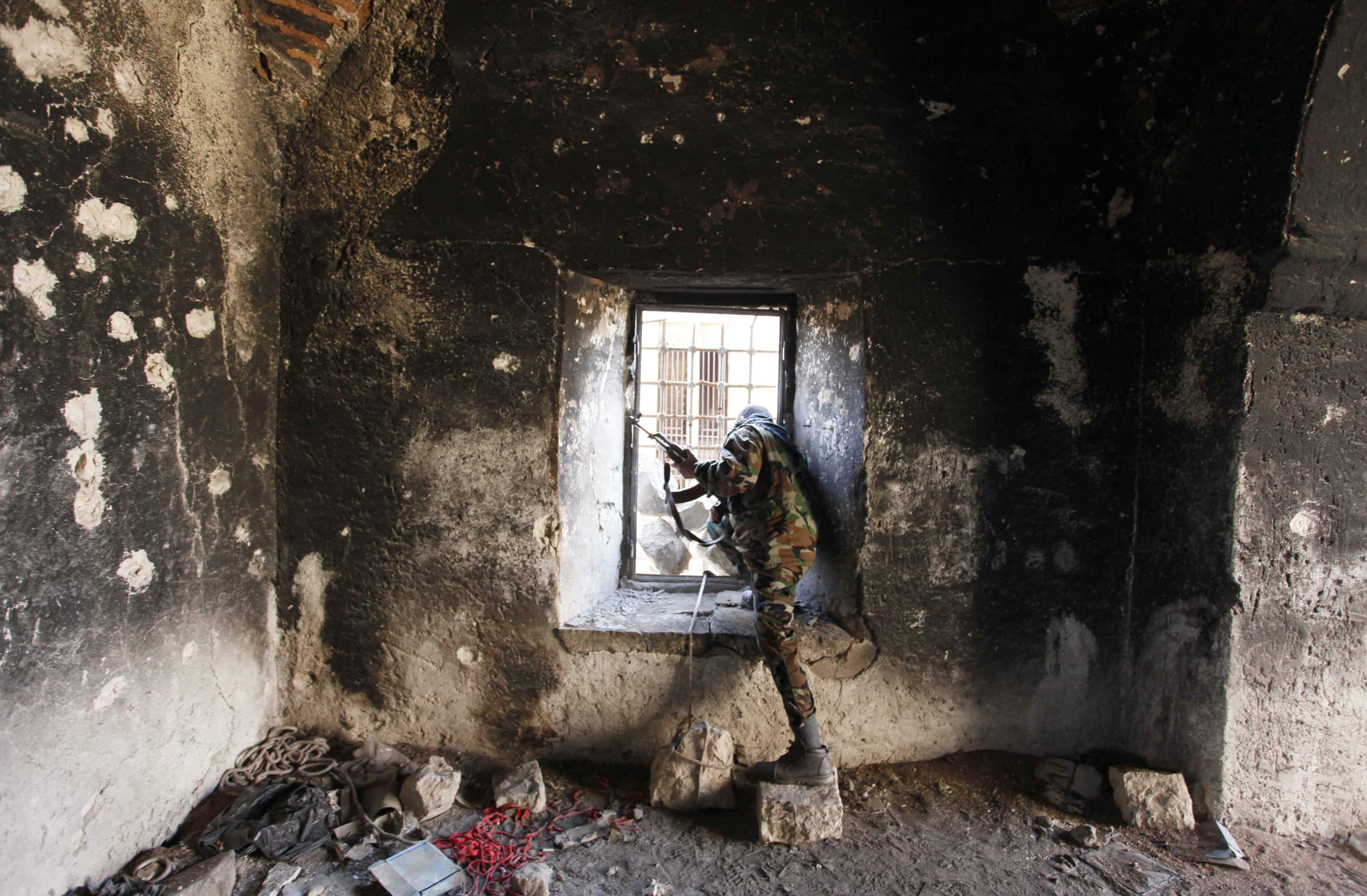 A Free Syrian Army fighter looks through a window of a damaged house in Old Aleppo. The Syrian photographer who took this picture and others for Reuters on a freelance basis was killed while covering fighting in Aleppo on 20 December 2013, REUTERS/Molhem Barakat