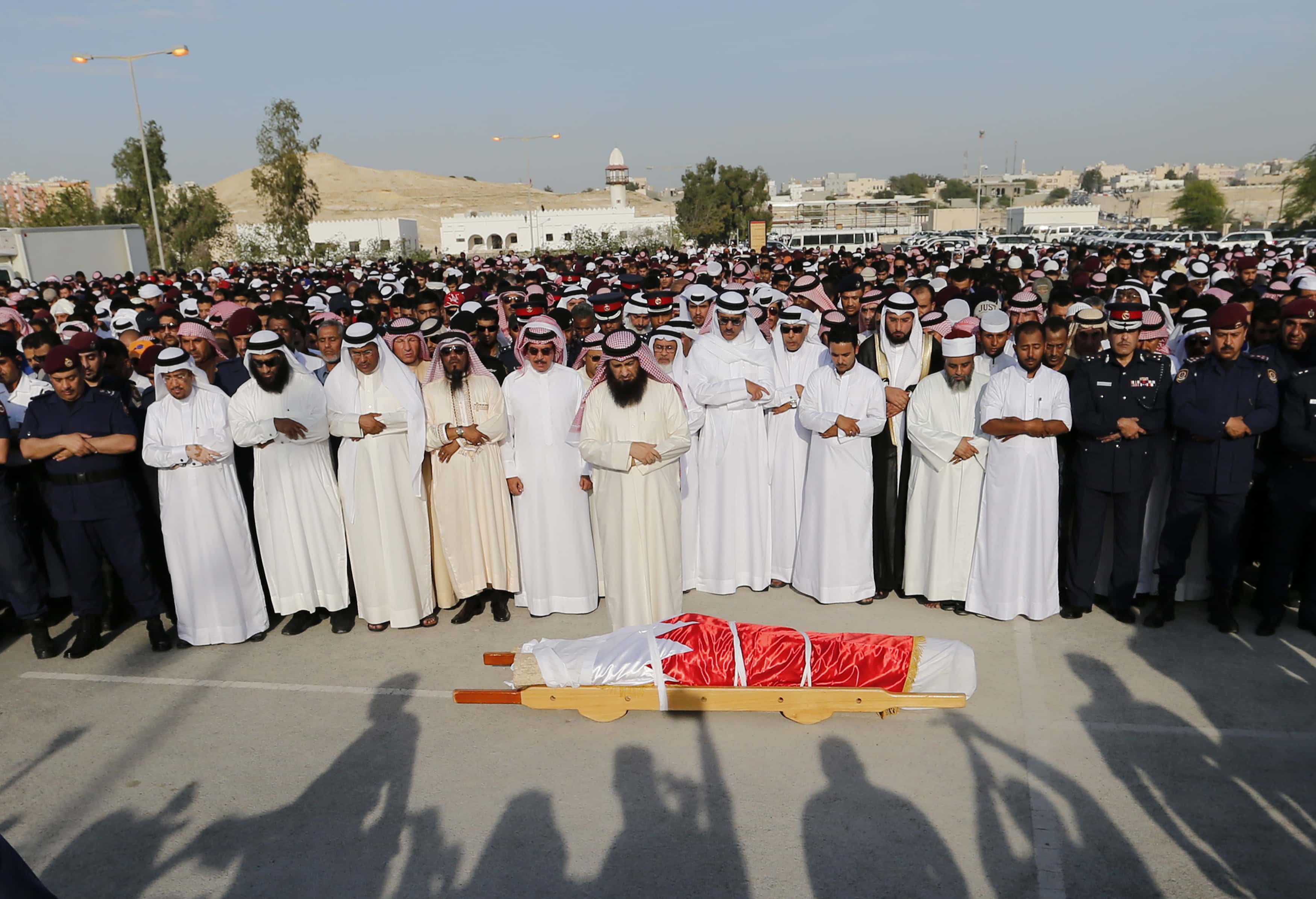 Mourners, including family members, pray on 4 March 2014 near the body of one of the policemen killed in Daih during a protest , REUTERS/Hamad I Mohammed