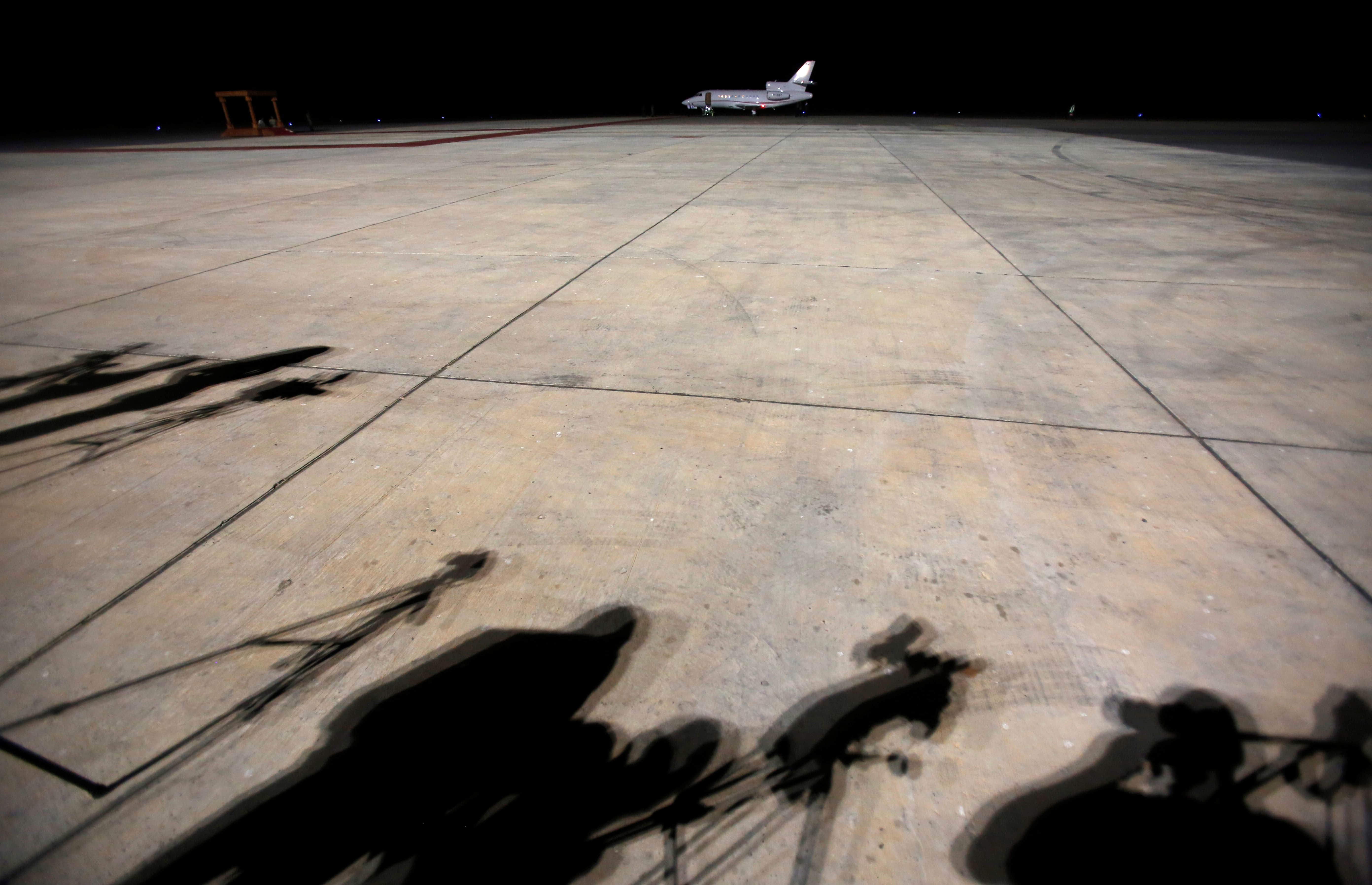 Journalists cast shadows as they await former Gambian President Yahya Jammeh's arrival at the airport of Banjul, Gambia, 21 January 2017, REUTERS/Thierry Gouegnon