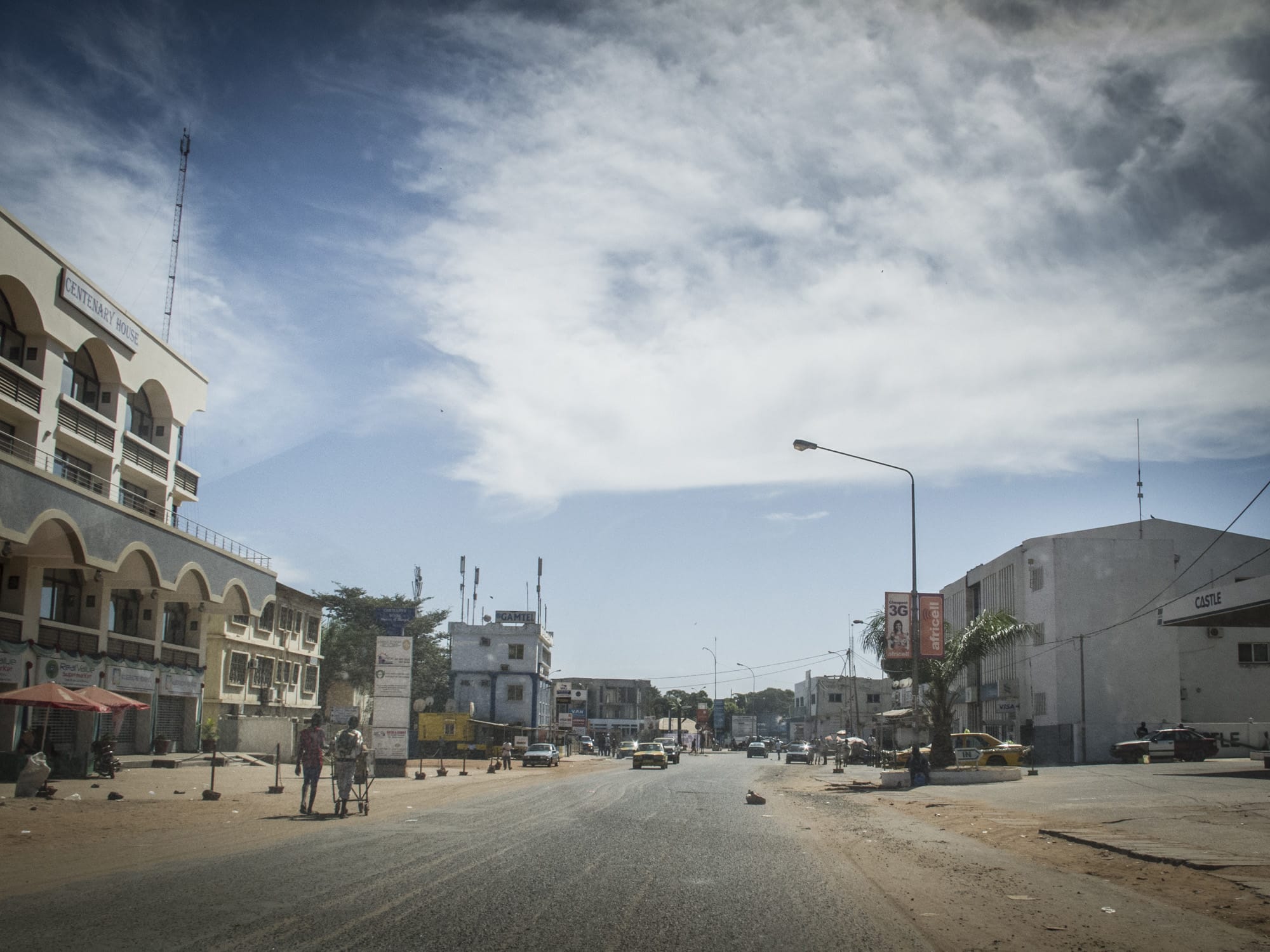 Residents walk on an empty street in Banjul, The Gambia, 30 December 2014, AP Photo/Jason Florio
