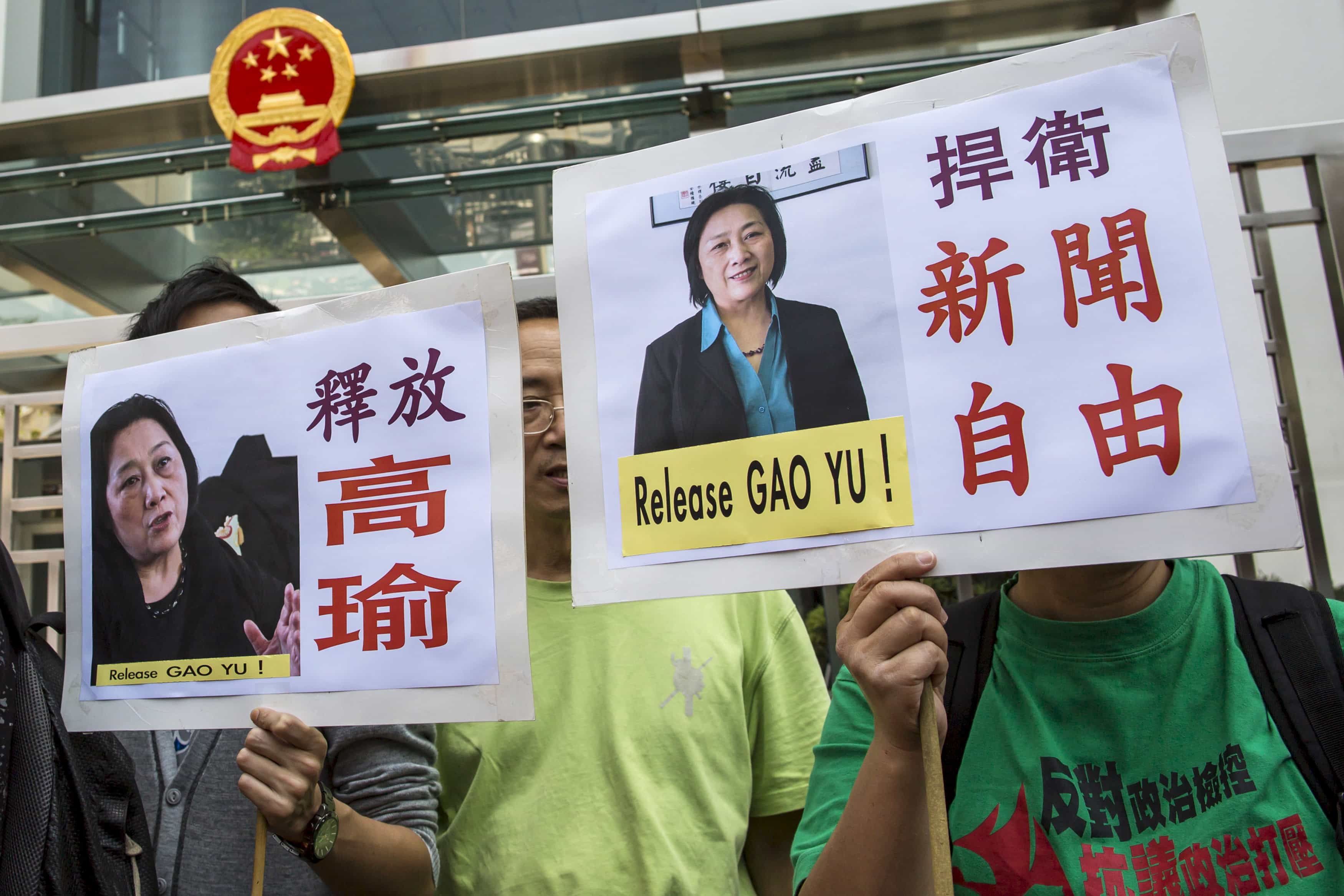 Pro-democracy protesters hold up signs during a demonstration calling for the release of Chinese journalist Gao Yu outside the Chinese liaison office in Hong Kong April 17, 2015. , REUTERS/Tyrone Siu