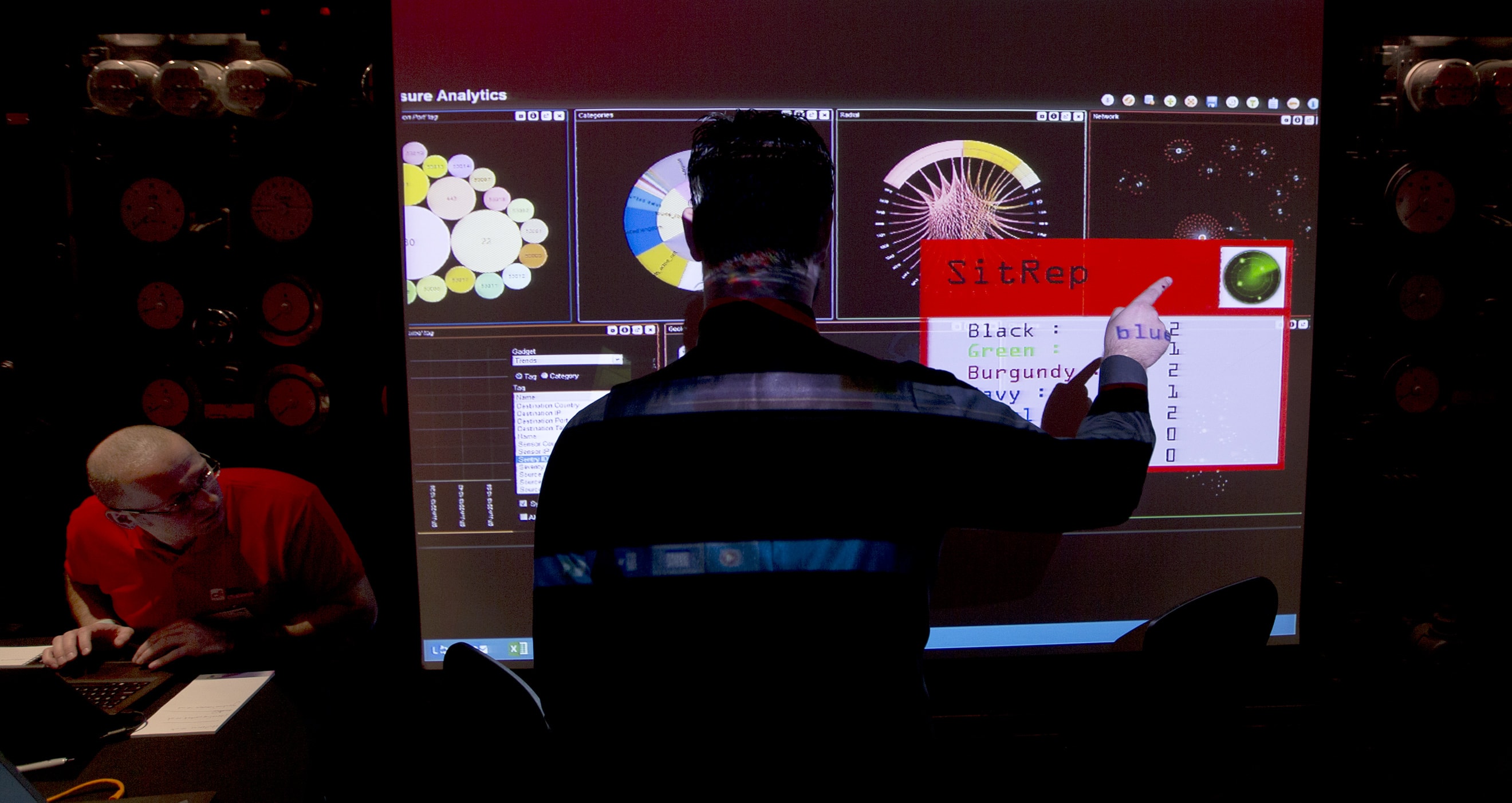 A representative of GCHQ points to a screen in London, 14 March 2014, AP Photo/Alastair Grant