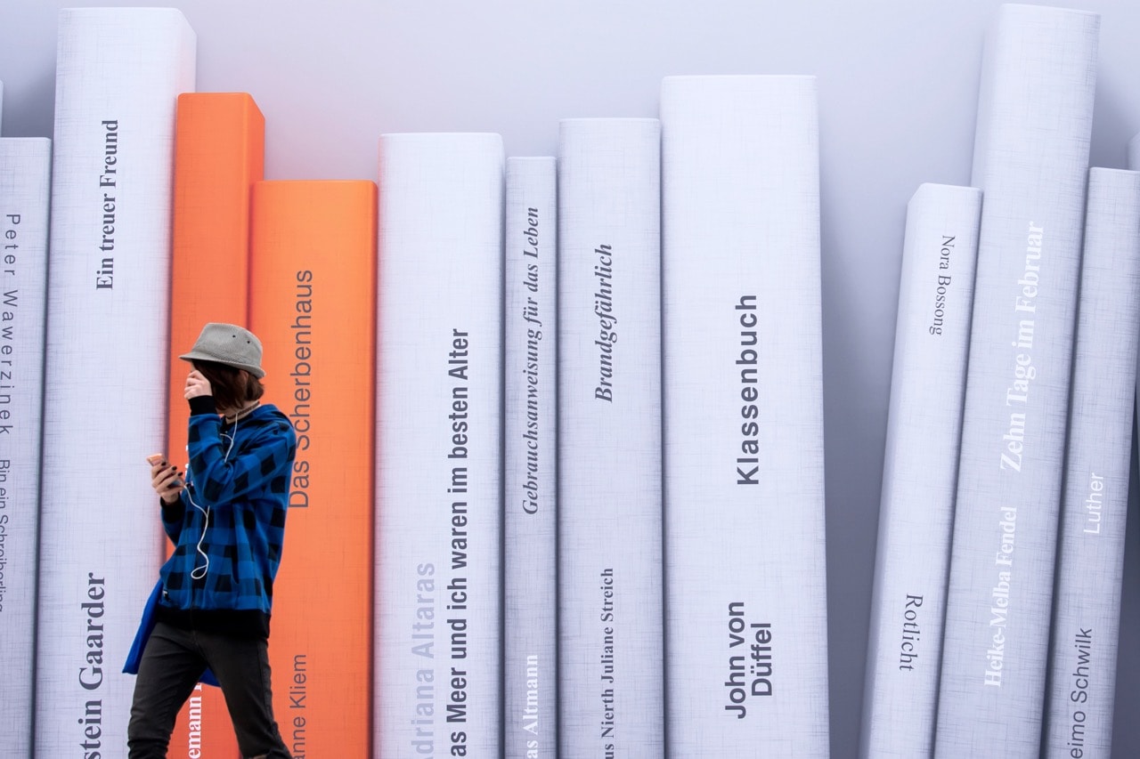 A visitor walks in front of a poster showing books at the Leipzig International Book Fair in Leipzig, Germany, 23 March 2017, AP Photo/Jens Meyer