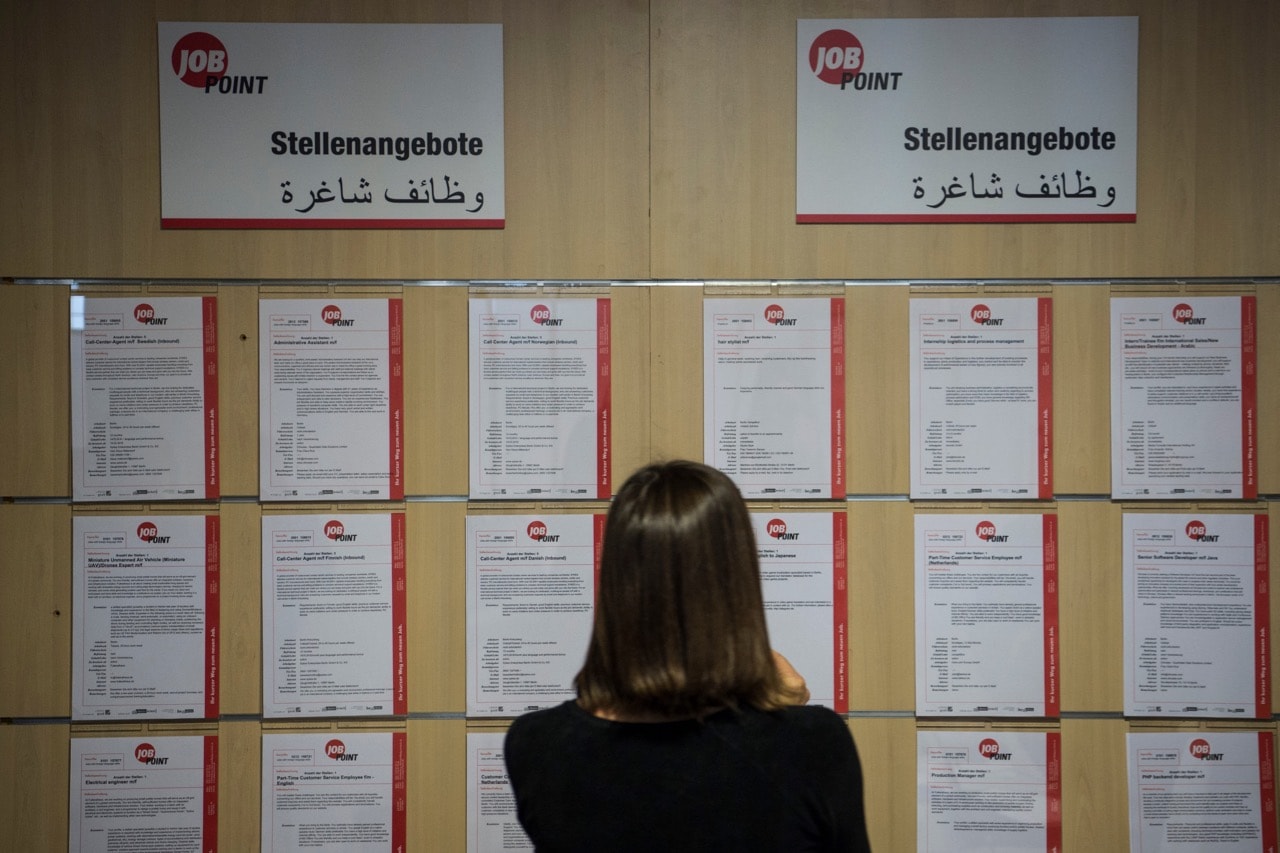 A journalist looks at job offers during the inauguration of a new jobs counseling center for migrants and refugees at the former Tempelhof Airport in Berlin, 27 January 2016 , JOHN MACDOUGALL/AFP/Getty Images