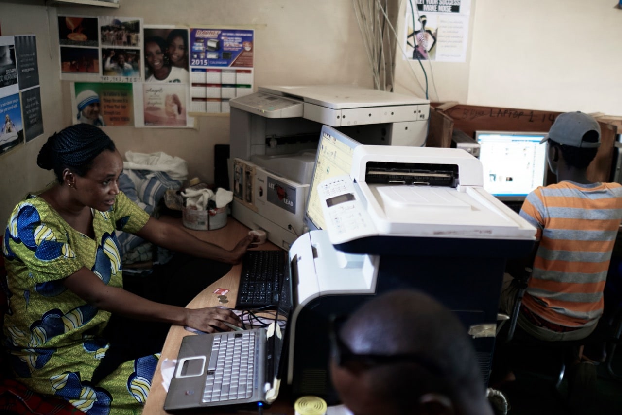 An owner sits at a computer in her Internet café in Zongo Area in central Accra, Ghana, 17 April 2015, Per-Anders Pettersson / Contributor/Getty Images