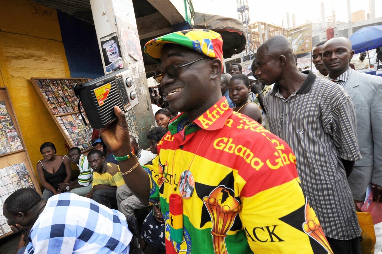 A man listens to a radio while watching a football match in Kumasi, Ghana, 3 February 2008, JOE KLAMAR/AFP/Getty Images