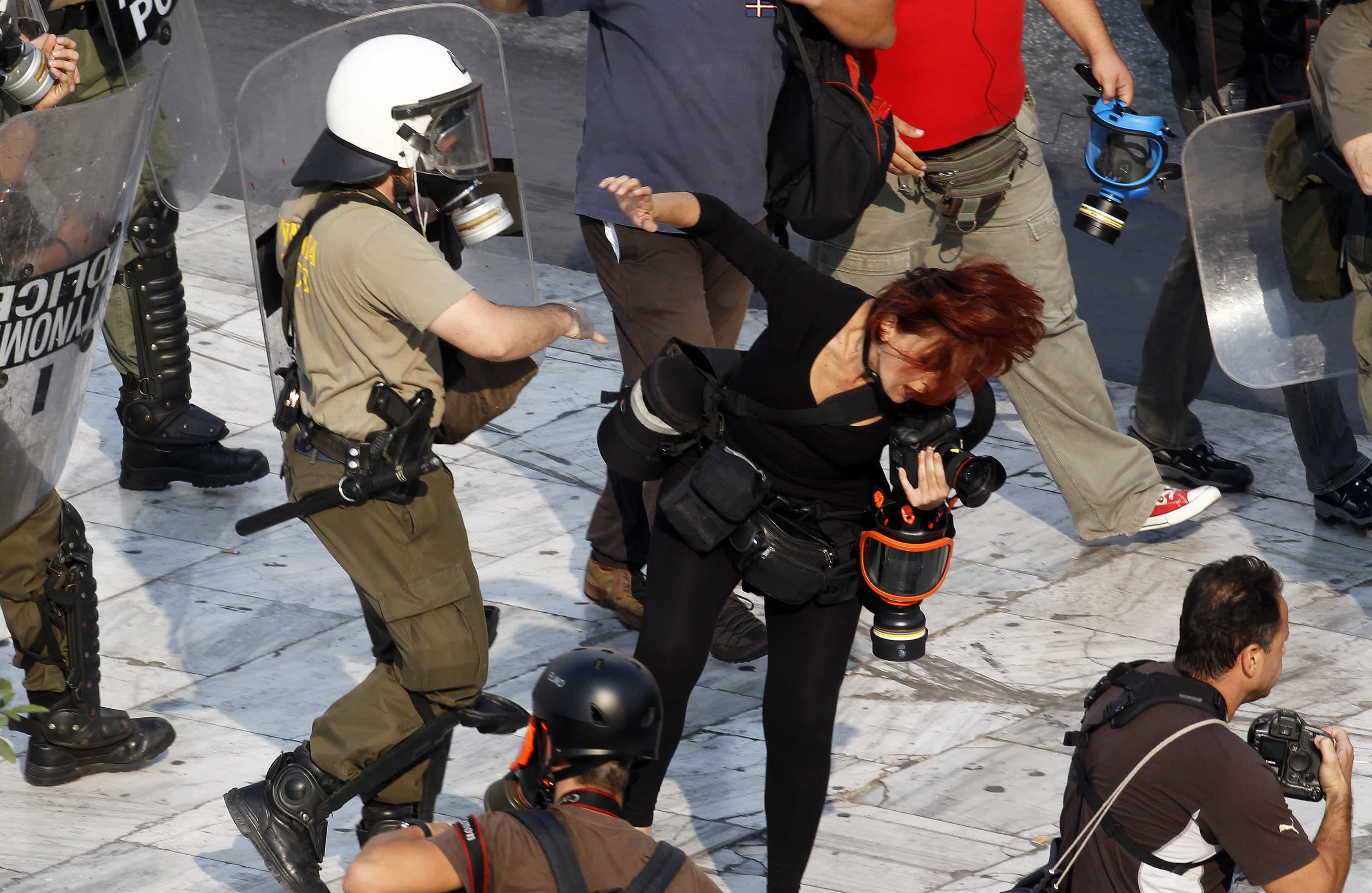 A riot policeman punches Greek photojournalist Tatiana Bolari during a demonstration in Athens' Syntagma (Constitution) square October 5, 2011, REUTERS/Yannis Behrakis