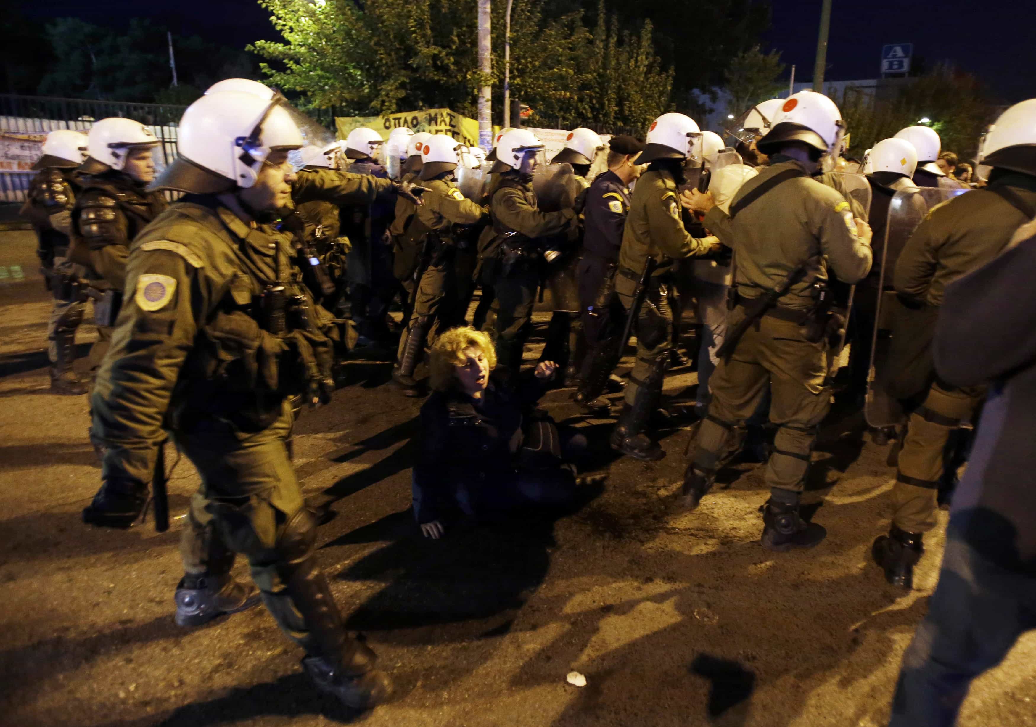 A woman falls down as riot police use tear gas to push back workers and supporters from the main entrance of ERT headquarters in the northern Athens suburb of Agia Paraskevi, Greece, 7 November 2013., AP Photo/Thanassis Stavrakis