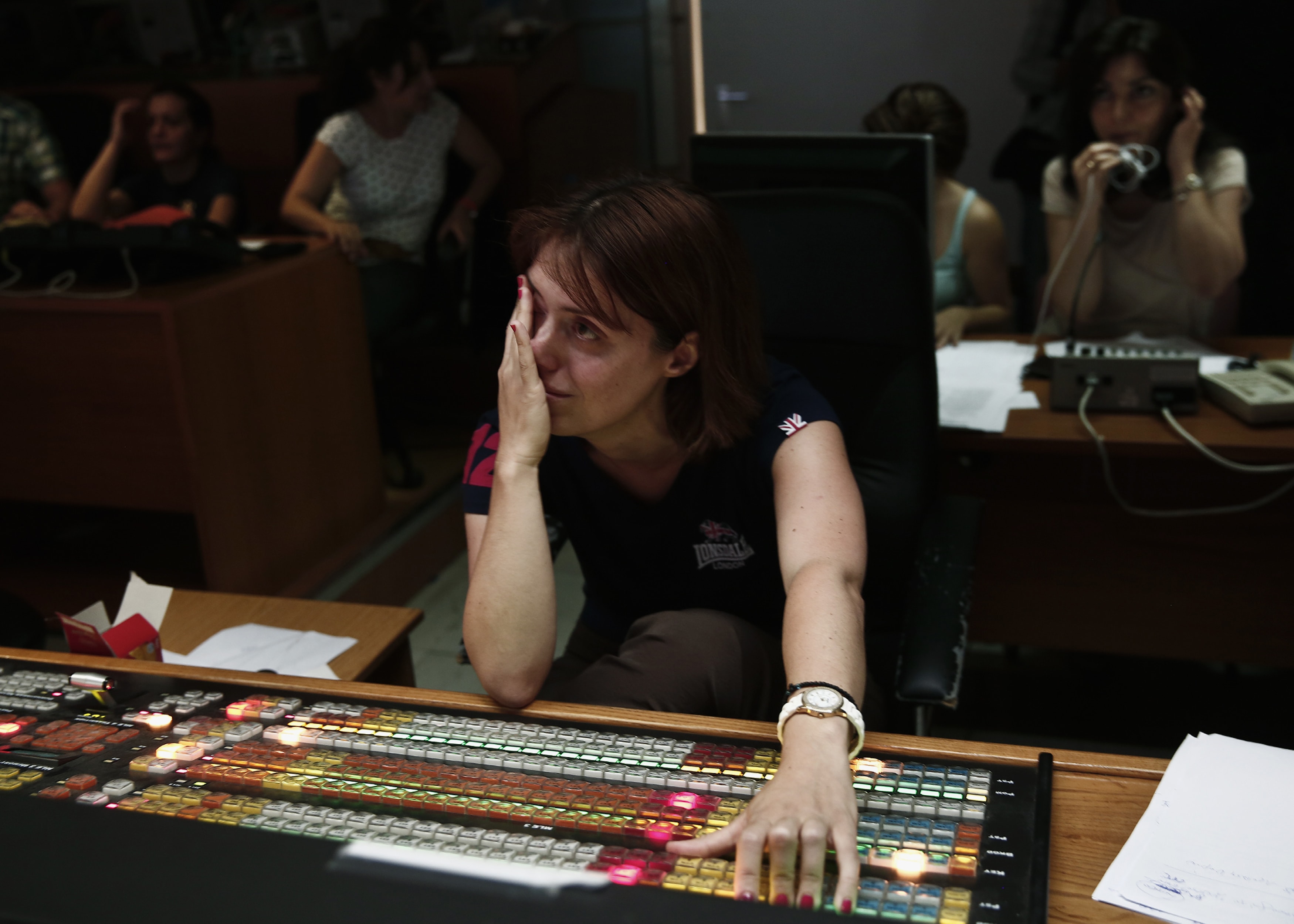 An employee wipes tears as she works with colleagues to broadcast a Web-Tv signal at the control room of the Greek state television ERT headquarters in Athens, 12 June 2013., REUTERS/Yorgos Karahalis