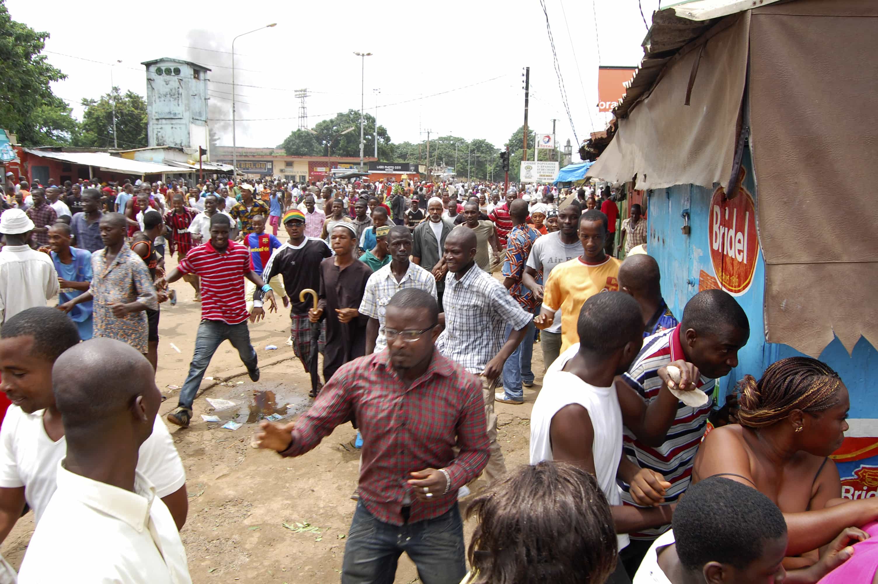 Guinean demonstrators flee as security forces disperse them from outside the stadium where tens of thousands gathered for a pro-democracy rally, in Conakry, 28 September 2009, AP Photo/Idrissa Soumare