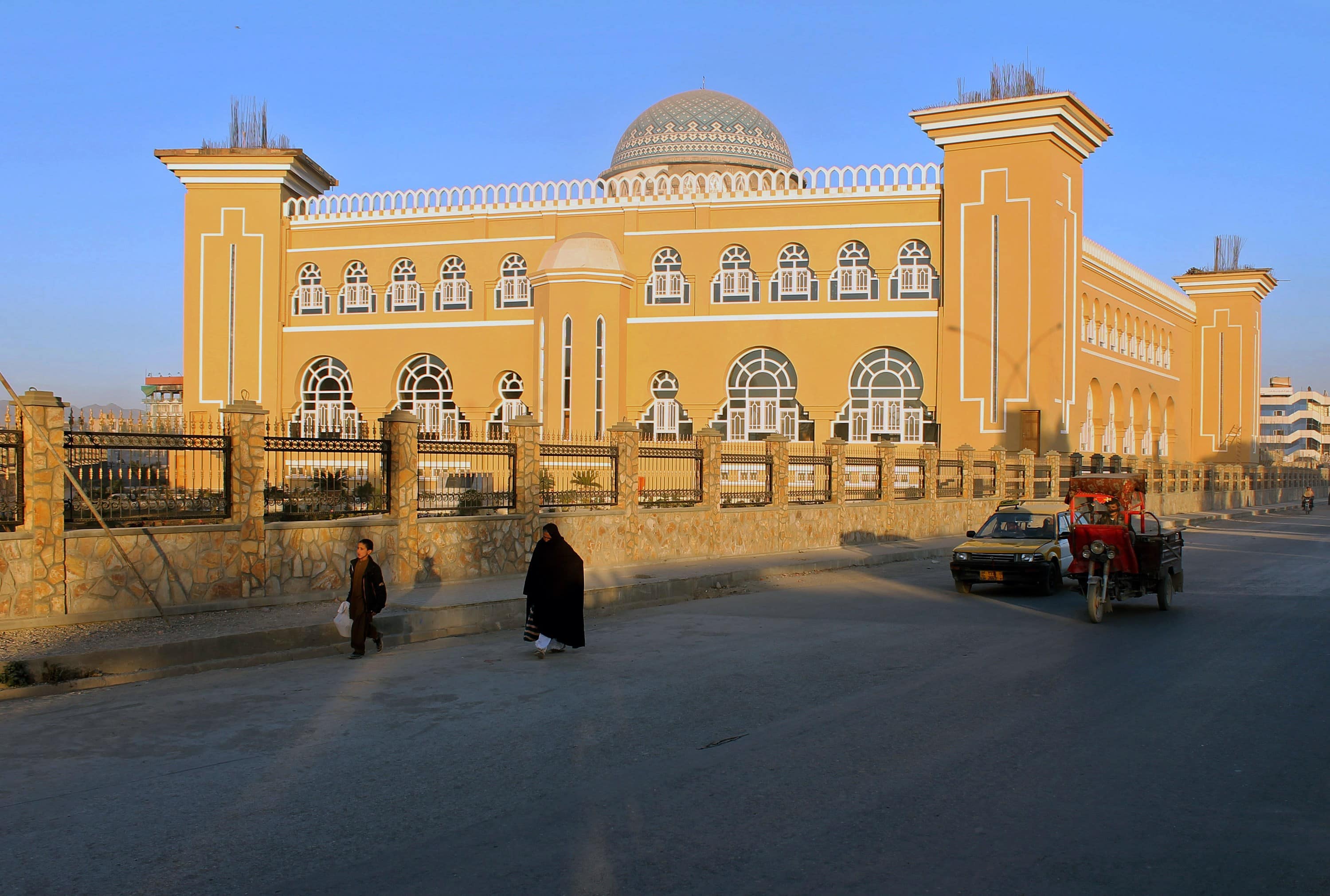 An Afghan woman walks with a child along a street in front of the Hazrat-e-Farooq mosque in Kandahar city, JAVED TANVEER/AFP/Getty Images