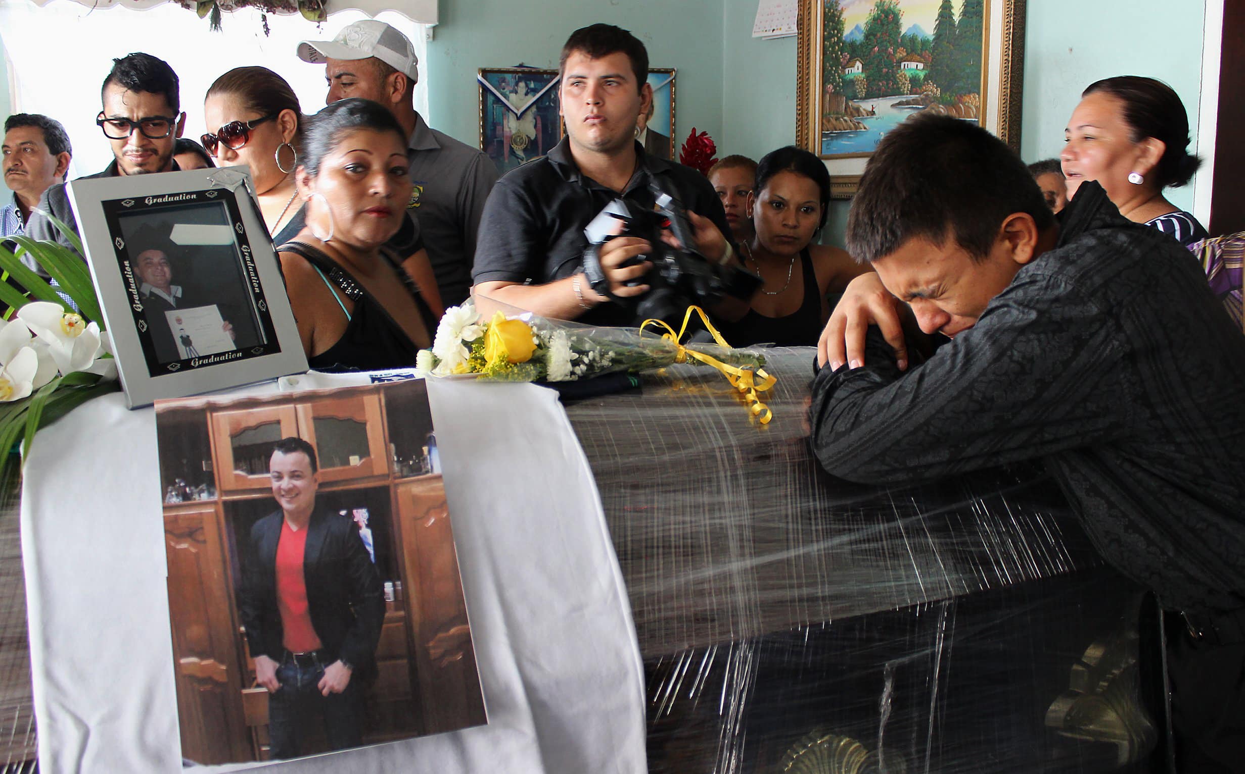 A relative of slain television journalist Herlyn Espinal mourns over his coffin during a wake at his home in Santa Rita municipality, in the outskirts of San Pedro Sula July 22, 2014. , REUTERS/Stringer