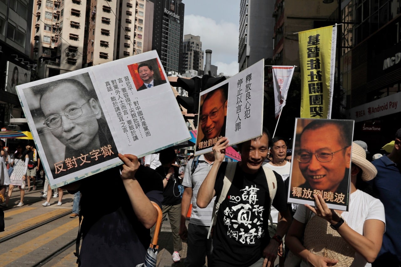 Protesters carry carry pictures of jailed Chinese Nobel Peace laureate Liu Xiaobo during a pro-democracy protest in Hong Kong, 1 July 2017, AP Photo/Vincent Yu