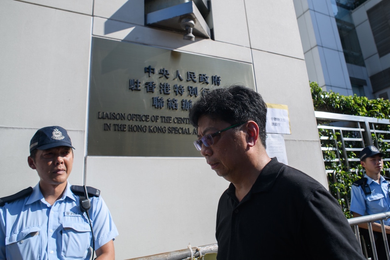 HKJA chairman Chris Yeung (C) walks past a letter (back R) from the group displayed outside the China's Liaison Office building in Hong Kong on 16 May 2018, after a journalist was arrested and left injured while trying to interview a human rights lawyer in Beijing, ANTHONY WALLACE/AFP/Getty Images