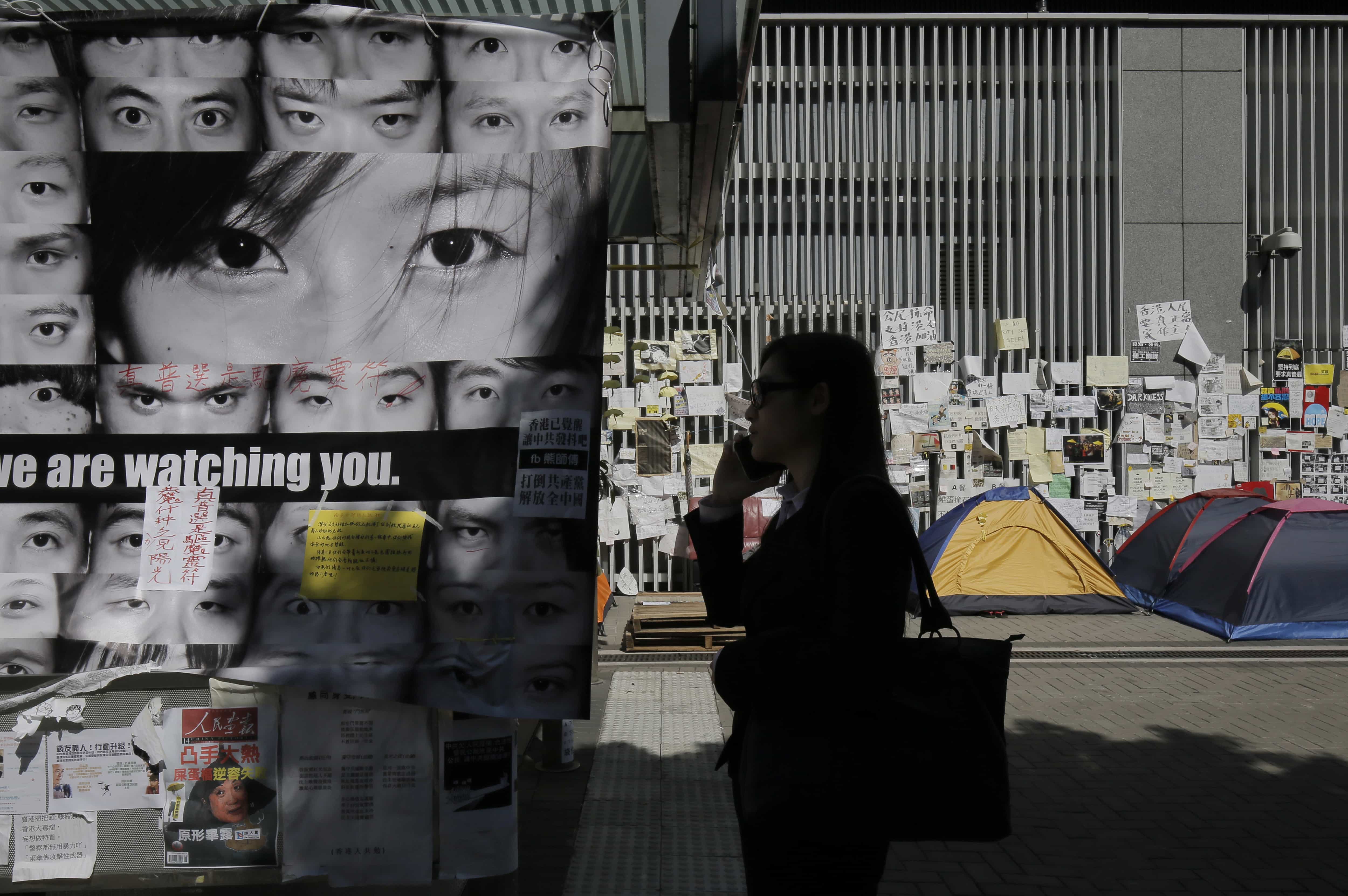 A woman talks on her phone next to some anti-government posters outside government headquarters in Hong Kong, 21 November 2014 , AP Photo/Vincent Yu