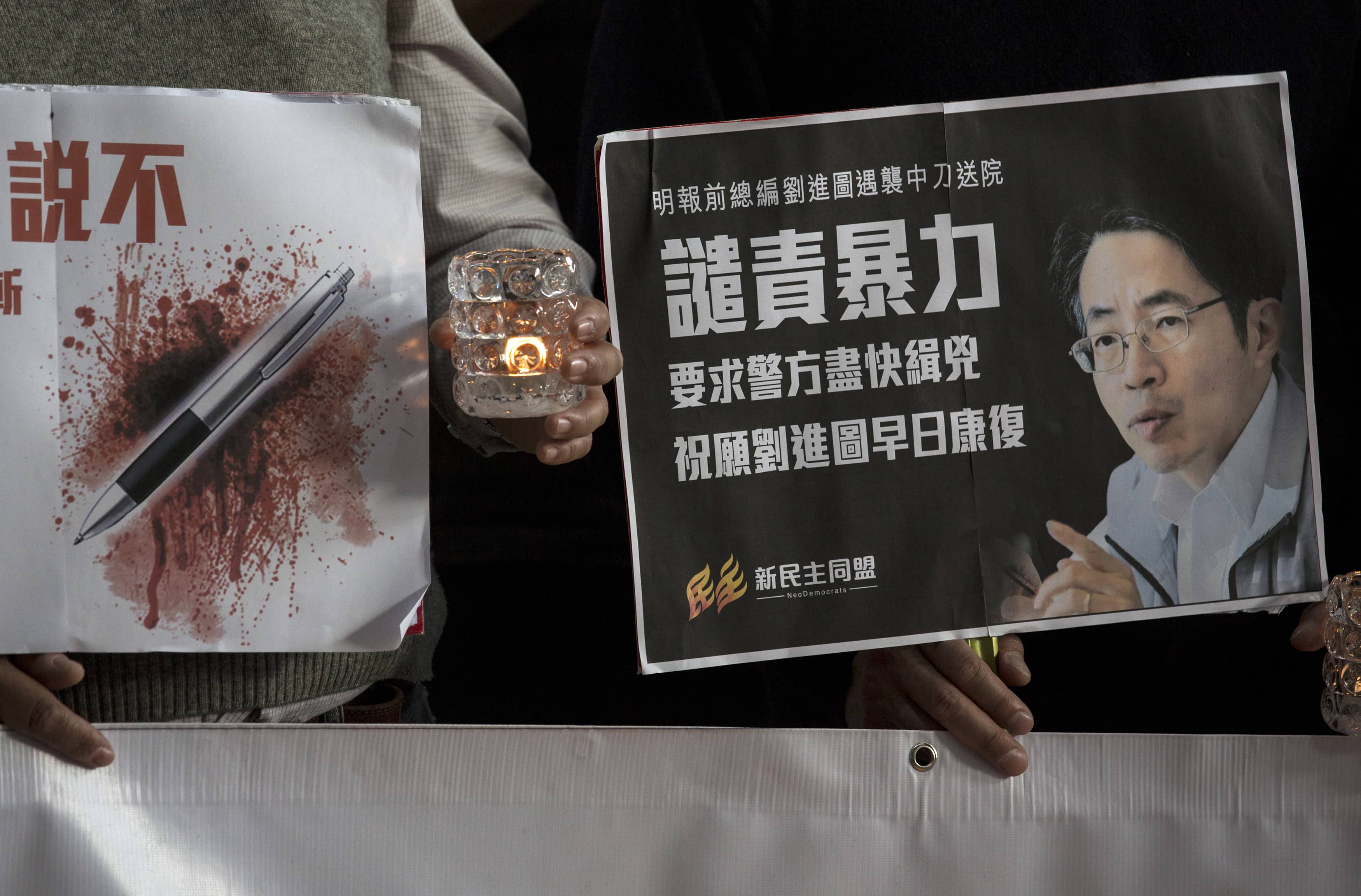 During a 26 February 2014 candlelight vigil in a Hong Kong hospital, activists urge the police to investigate the attack on Kevin Lau (whose image appears on the sign), REUTERS/Tyrone Siu