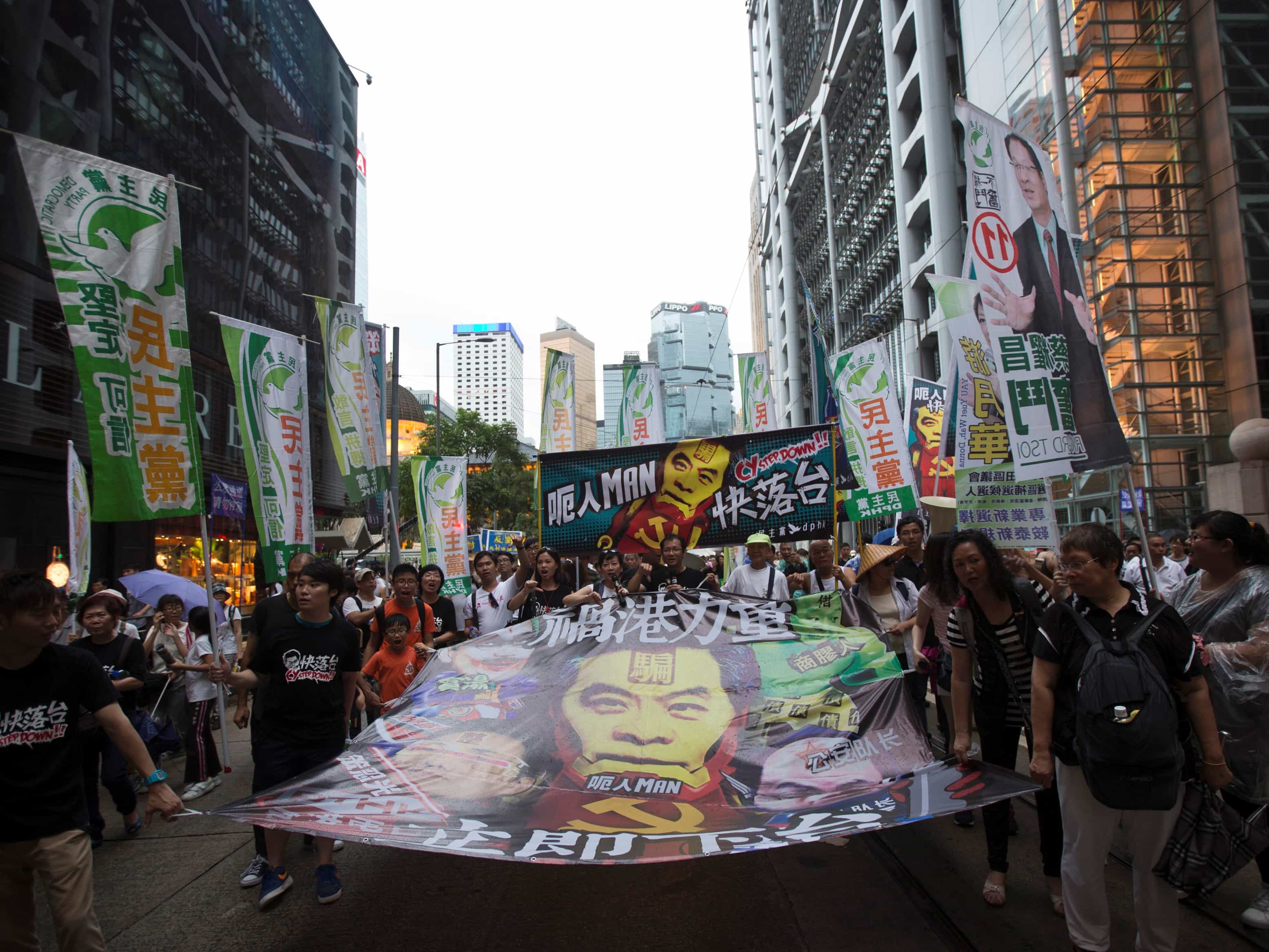 On 1 July 2013 pro-democracy protesters hold banners with the image of Hong Kong's Chief Executive Leung Chun-ying calling on him to step down, REUTERS/Tyrone Si